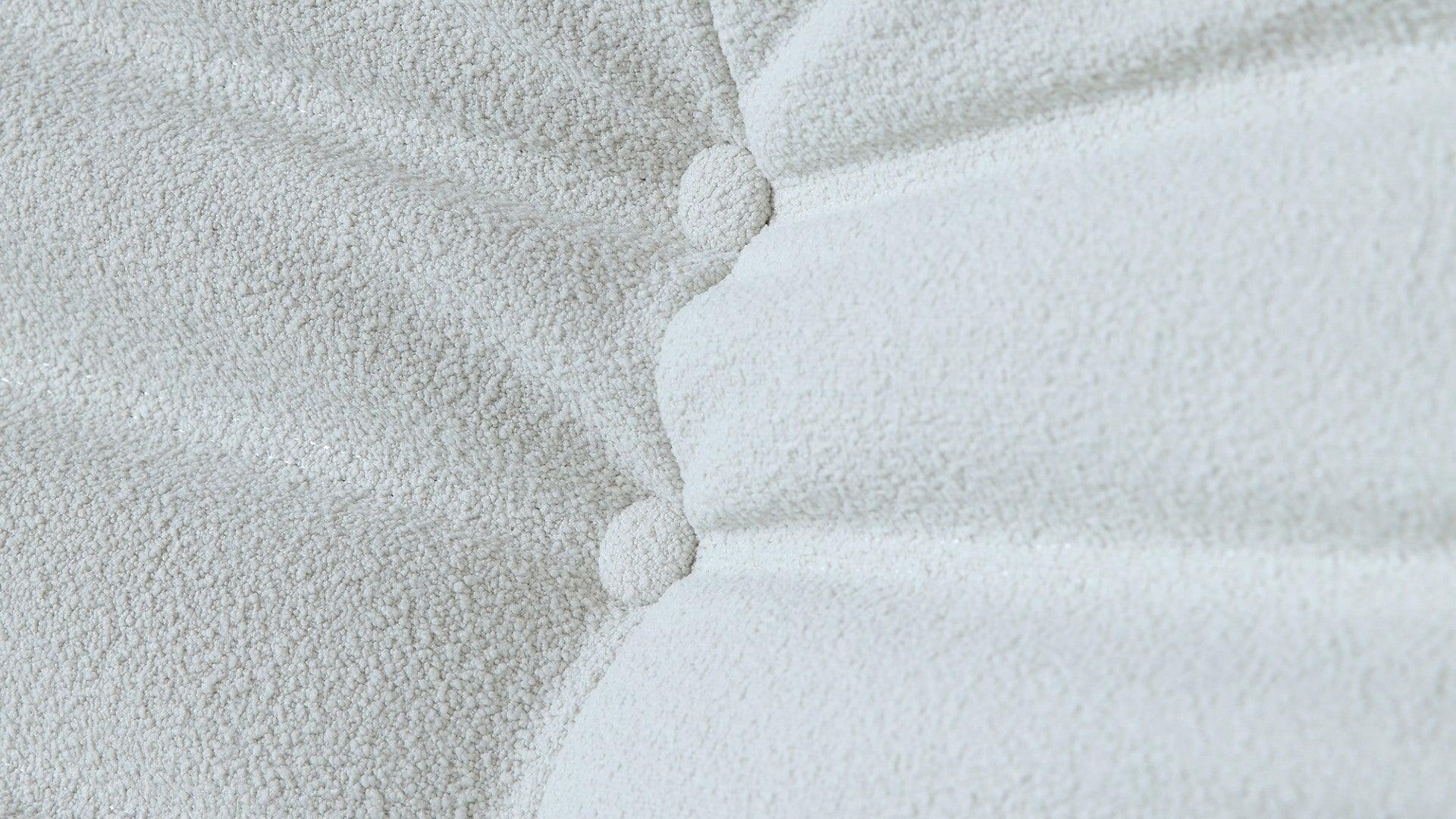 Close-up of buttons of a white togo-style sofa
