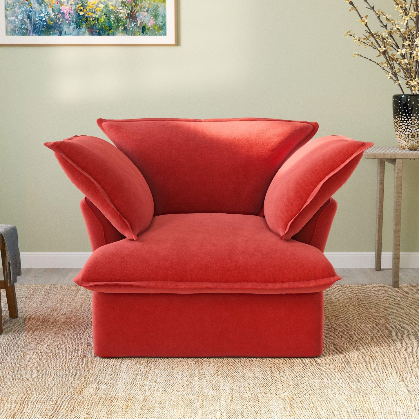 A plush red velvet modular sectional sofa in a cozy living room setting, with a cushioned backrest and seat.