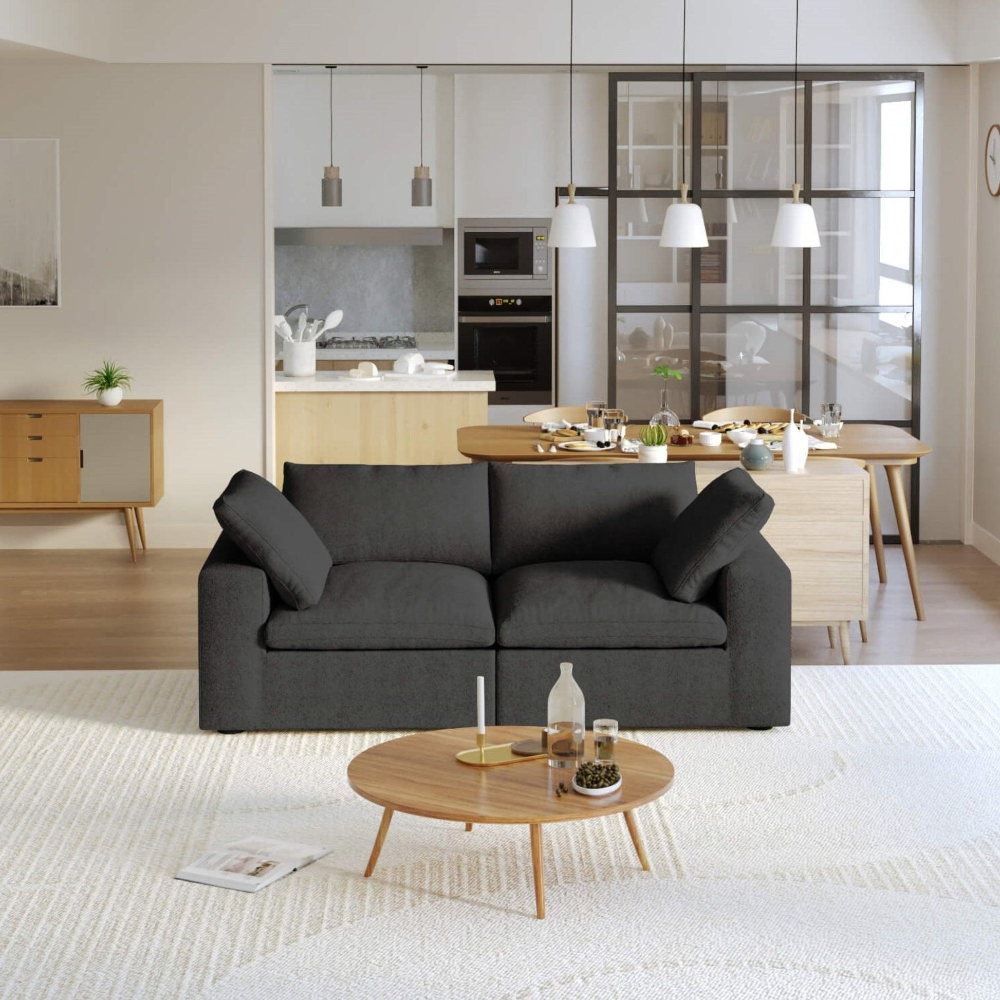 A modern black loveseat sectional sofa in a bright living room setting, featuring a white slipcover, and designed for small space functionality.