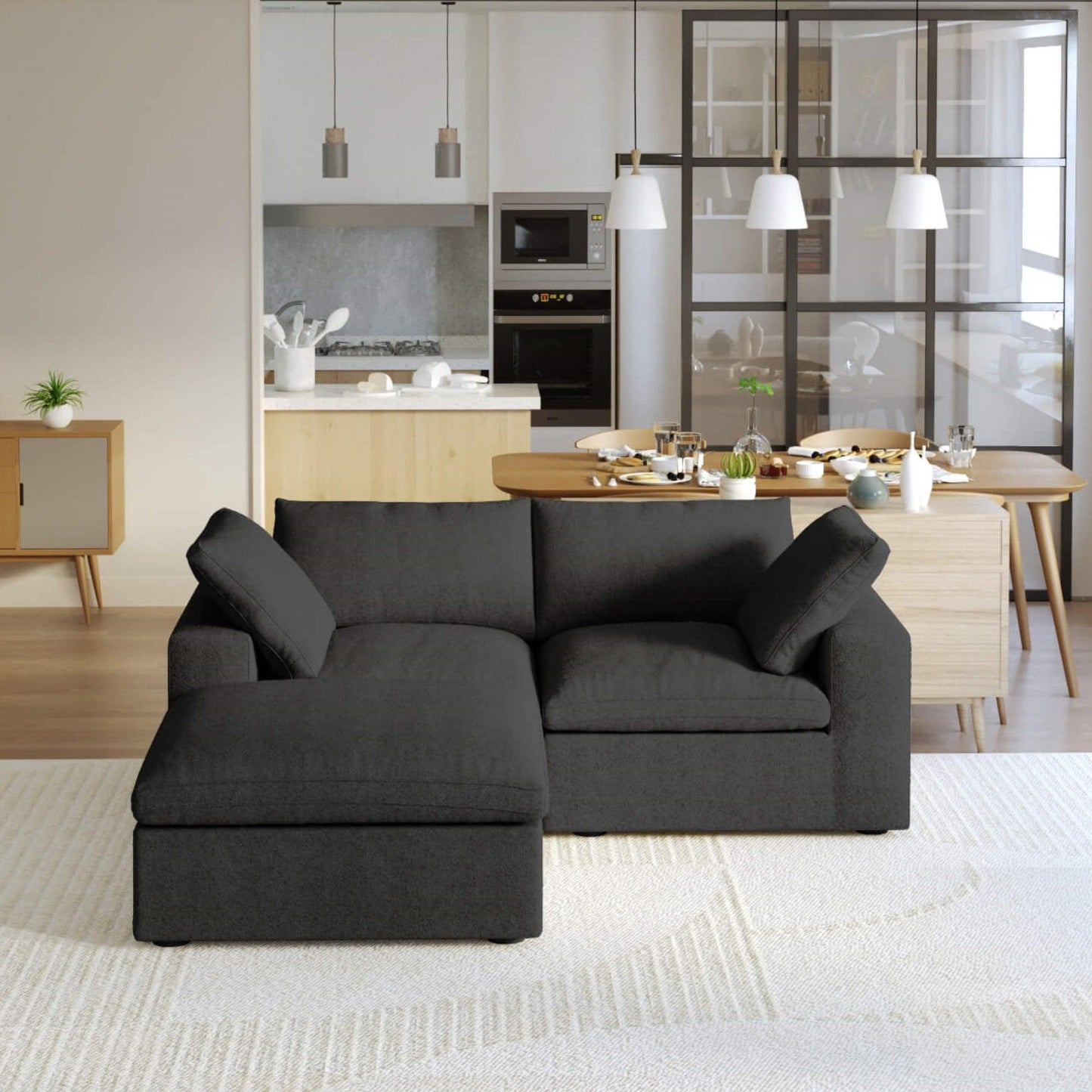 A black modular sectional sofa with a storage ottoman in a modern living room setting.
