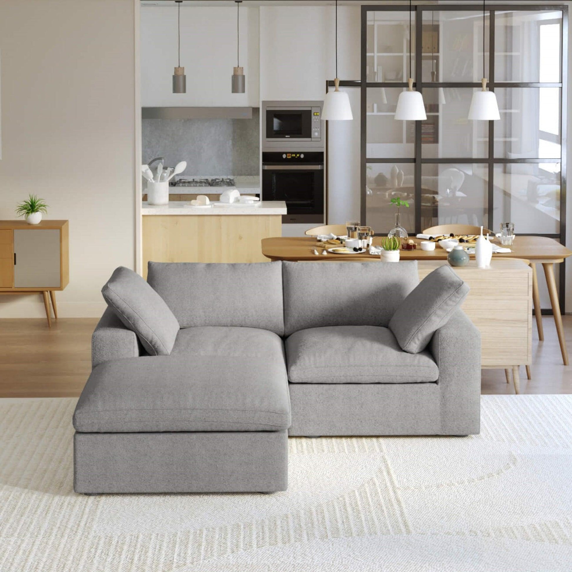 A gray modular sectional sofa with a storage ottoman in a modern living room setting.