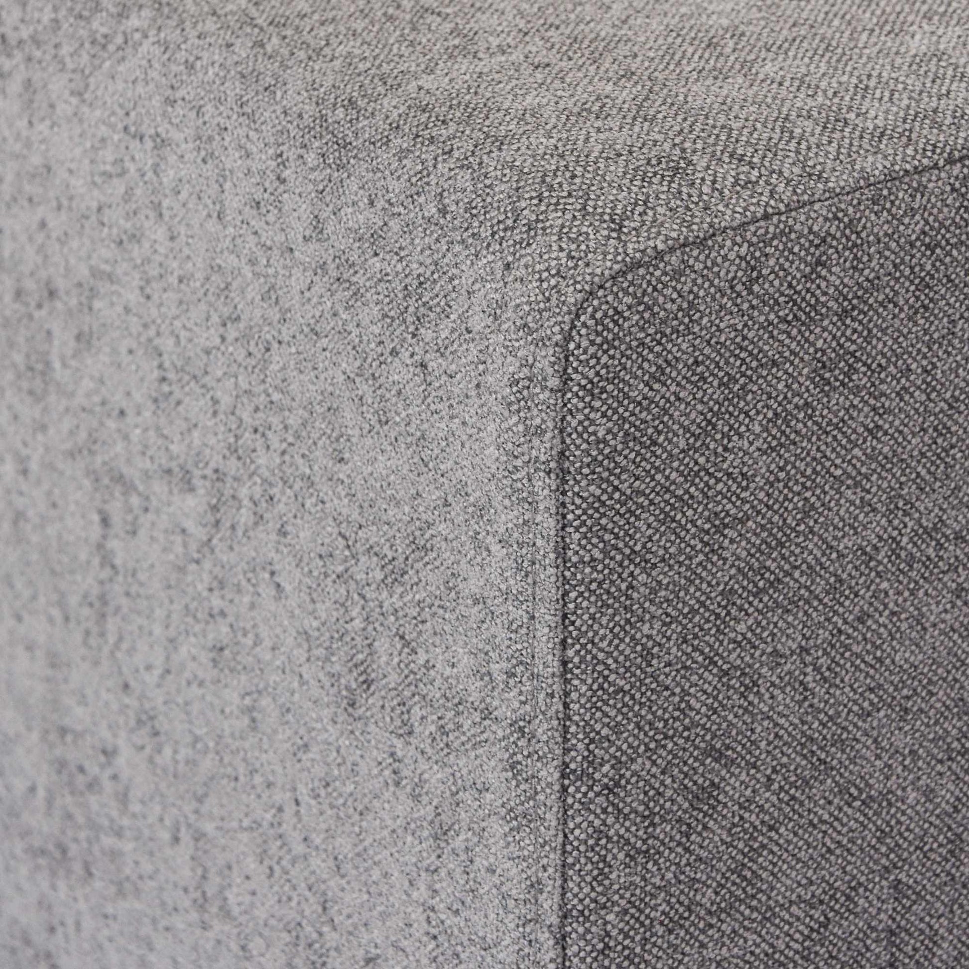 Close-up of a corner of an armrest of a gray sofa