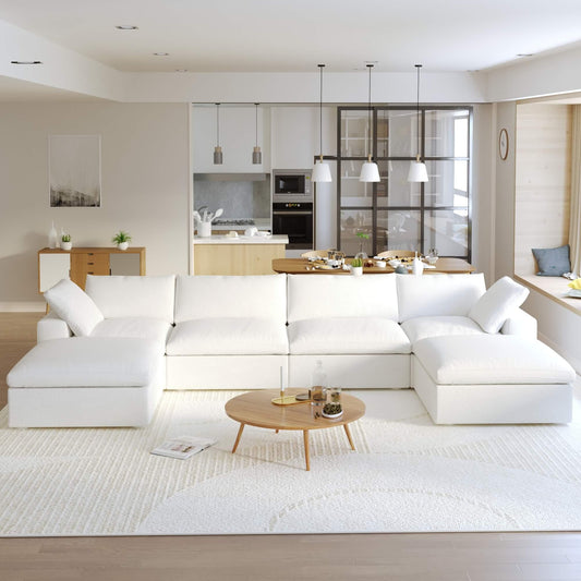 A large, U-shaped, white modular sectional sofa with storage ottoman in a modern living room setting.