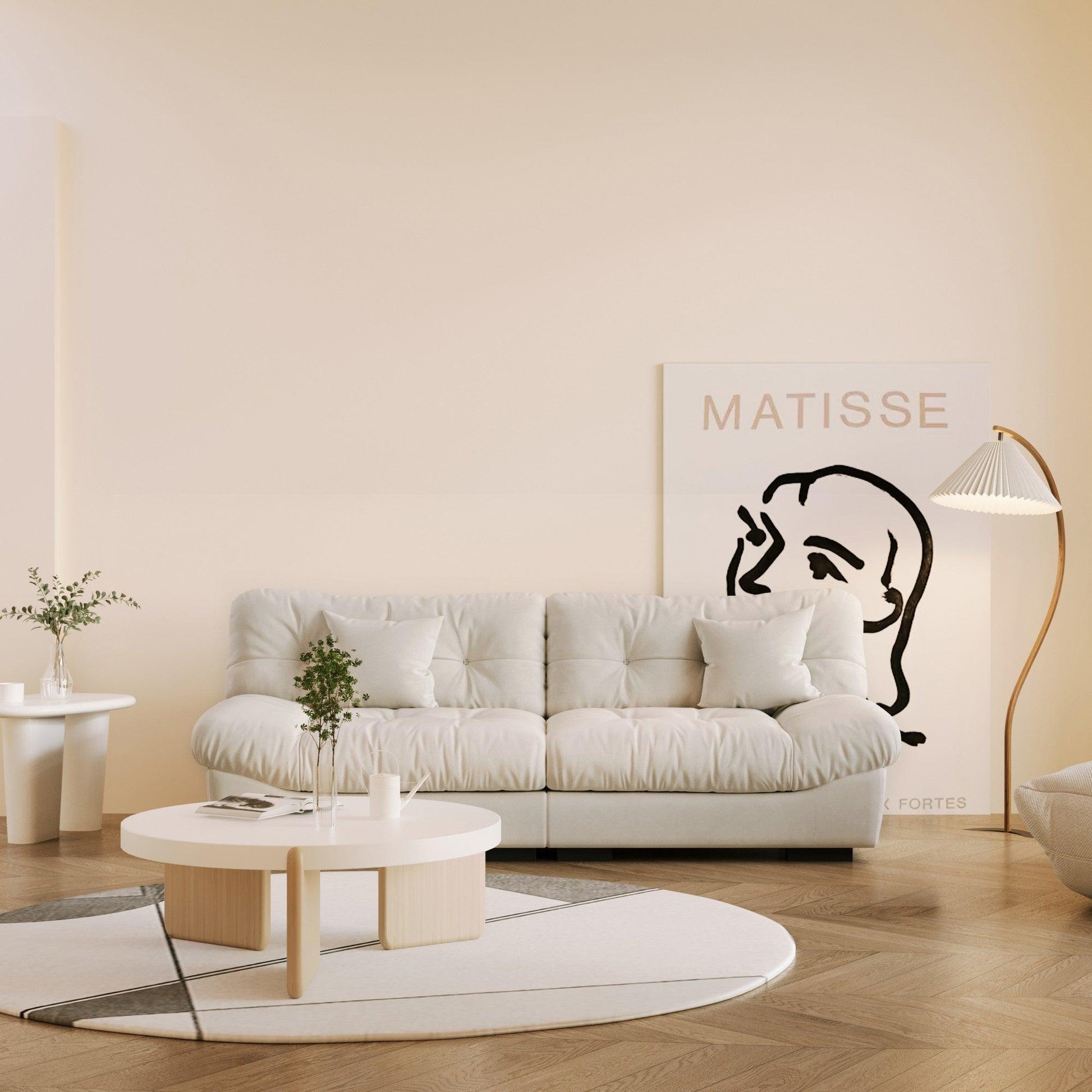 An 89-inch beige microfiber suede sofa with a solid hardwood frame, presented in a living room setting with minimalistic decor, including a 'Matisse' art print on the wall.