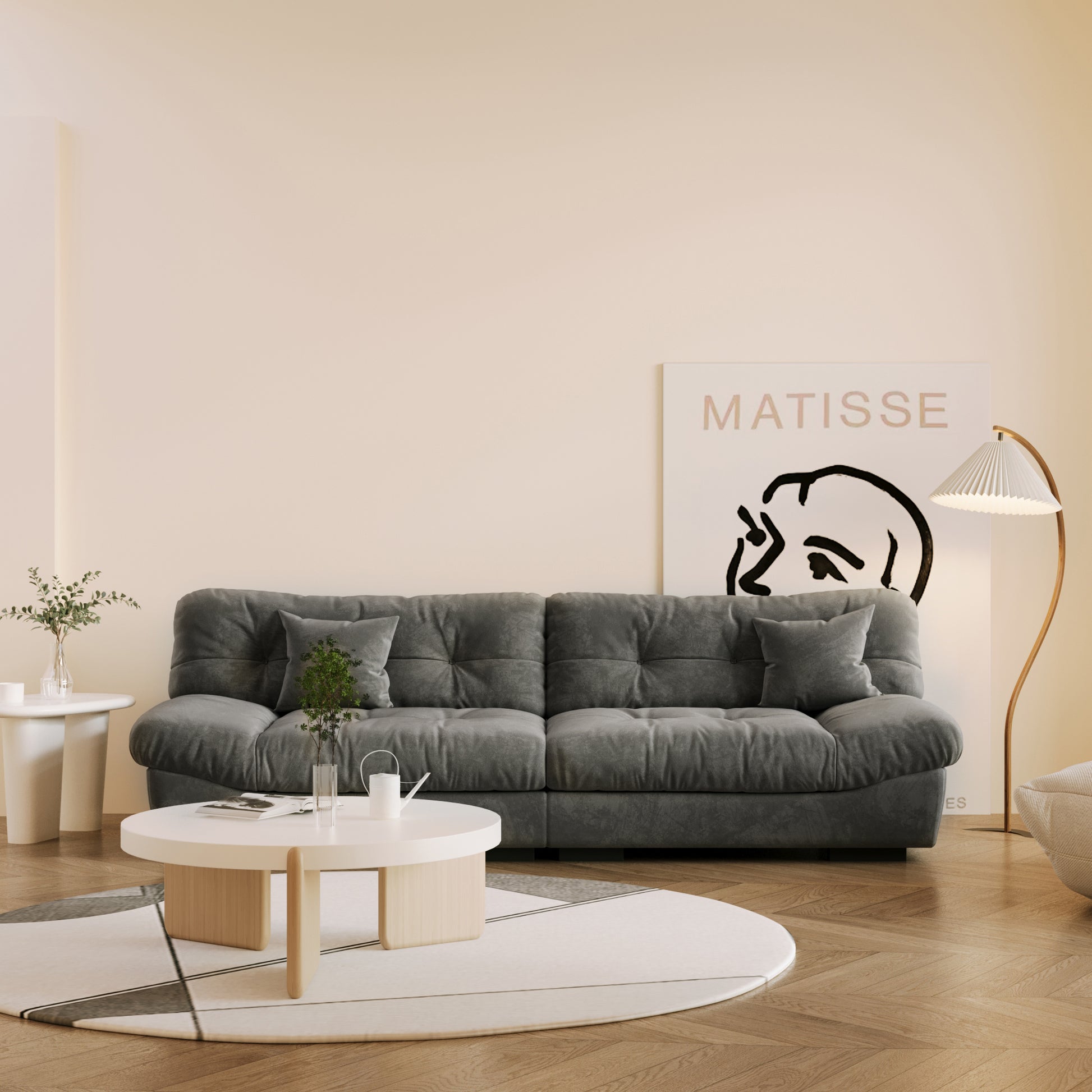 A gray microfiber suede sofa in a warm lightning with splitable seats placed in a room with minimalistic decor, including a 'Matisse' poster on the wall.