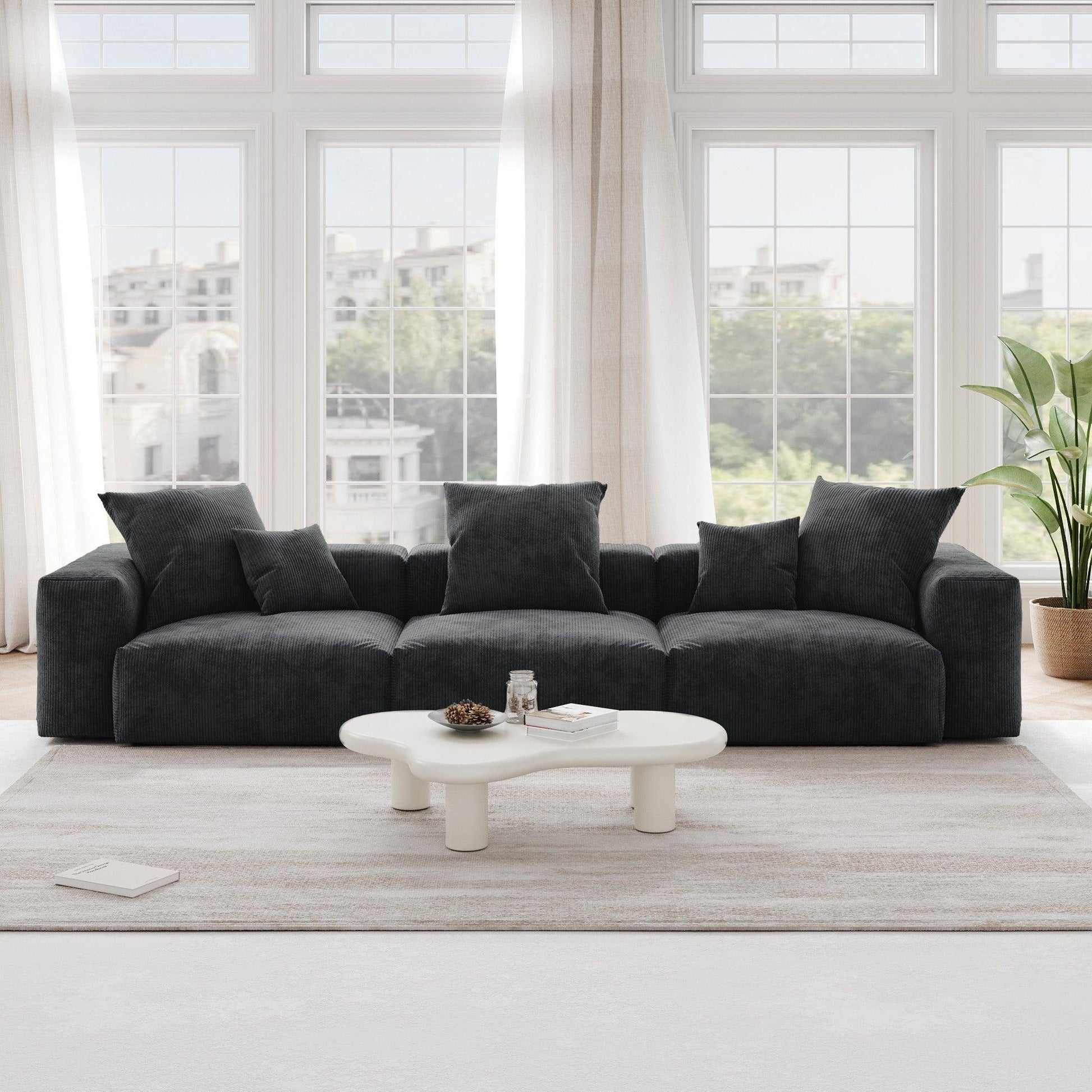 A black corduroy 3-seat sectional modular sofa with detachable armrests and removable covers, pet-friendly, displayed in a bright living space.