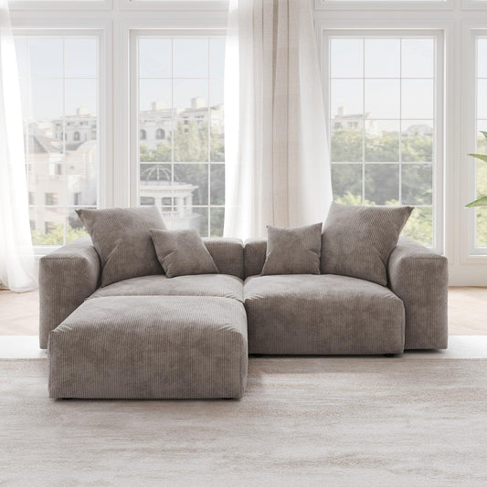 A brown corduroy sectional loveseat sofa with ottoman, detachable armrests, and removable covers, featuring a chaise lounge configuration placed in a room with large windows.