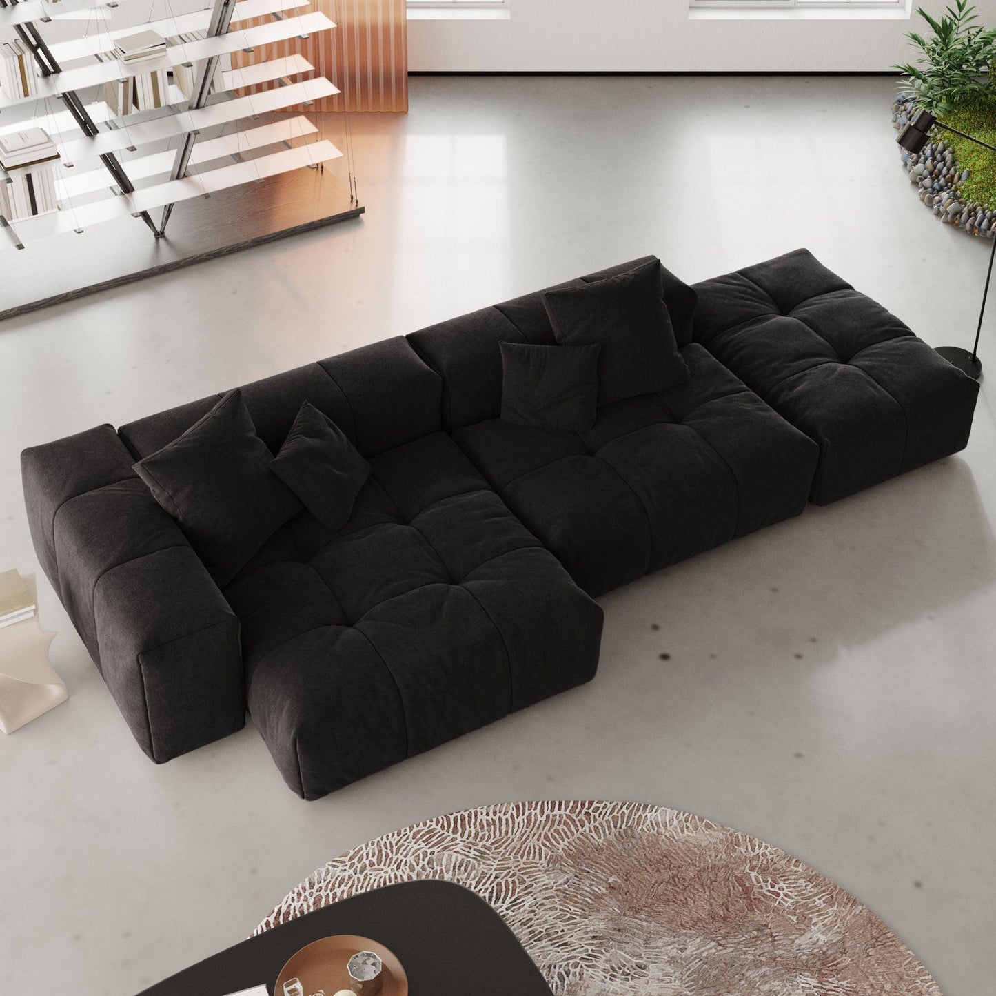 A modern, black 3-seat modular lounger sofa in white color with wide armrests and multiple accent pillows, arranged in a living room setting.