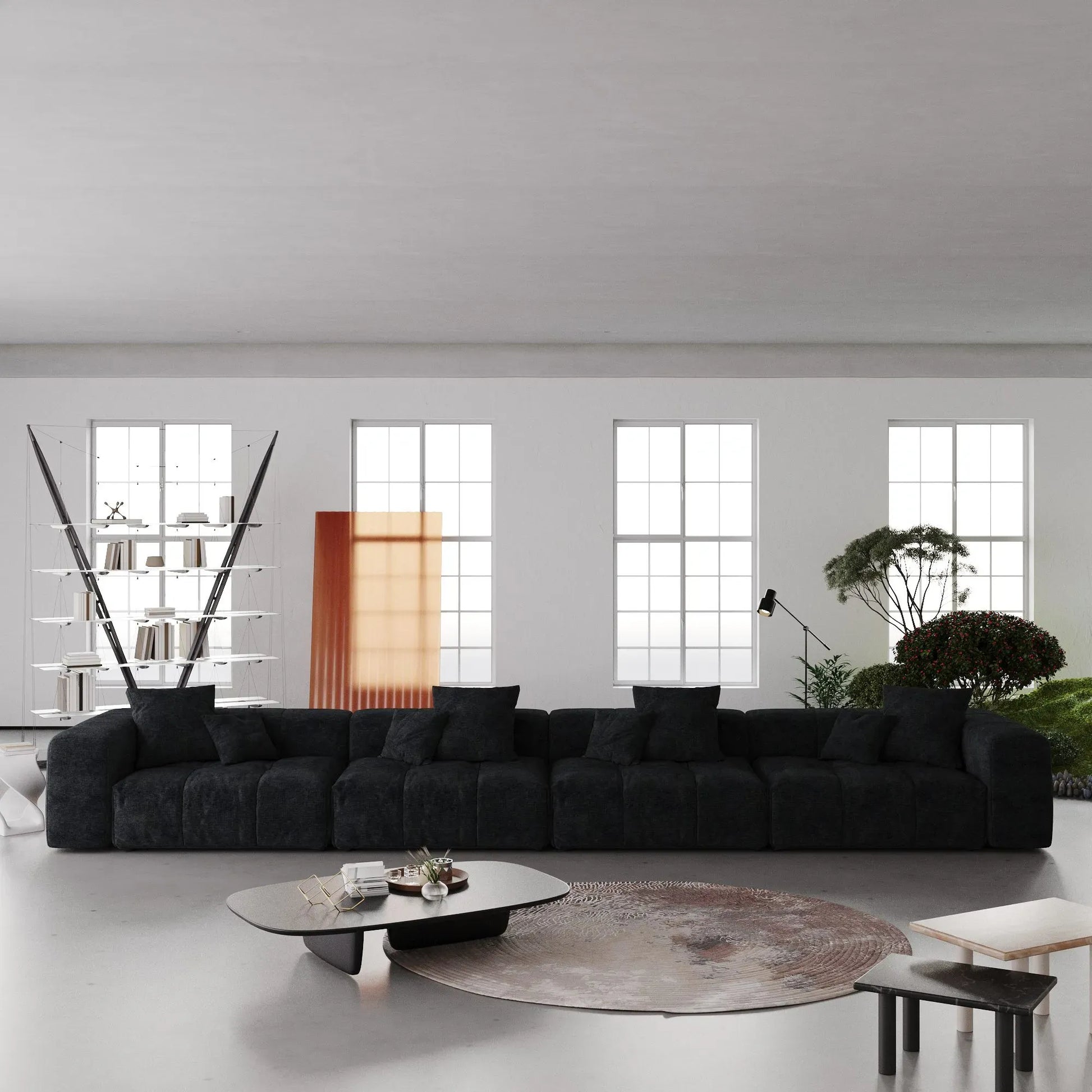 Modern living room with a large black 4-seater sofa, round coffee table, and decorative elements.