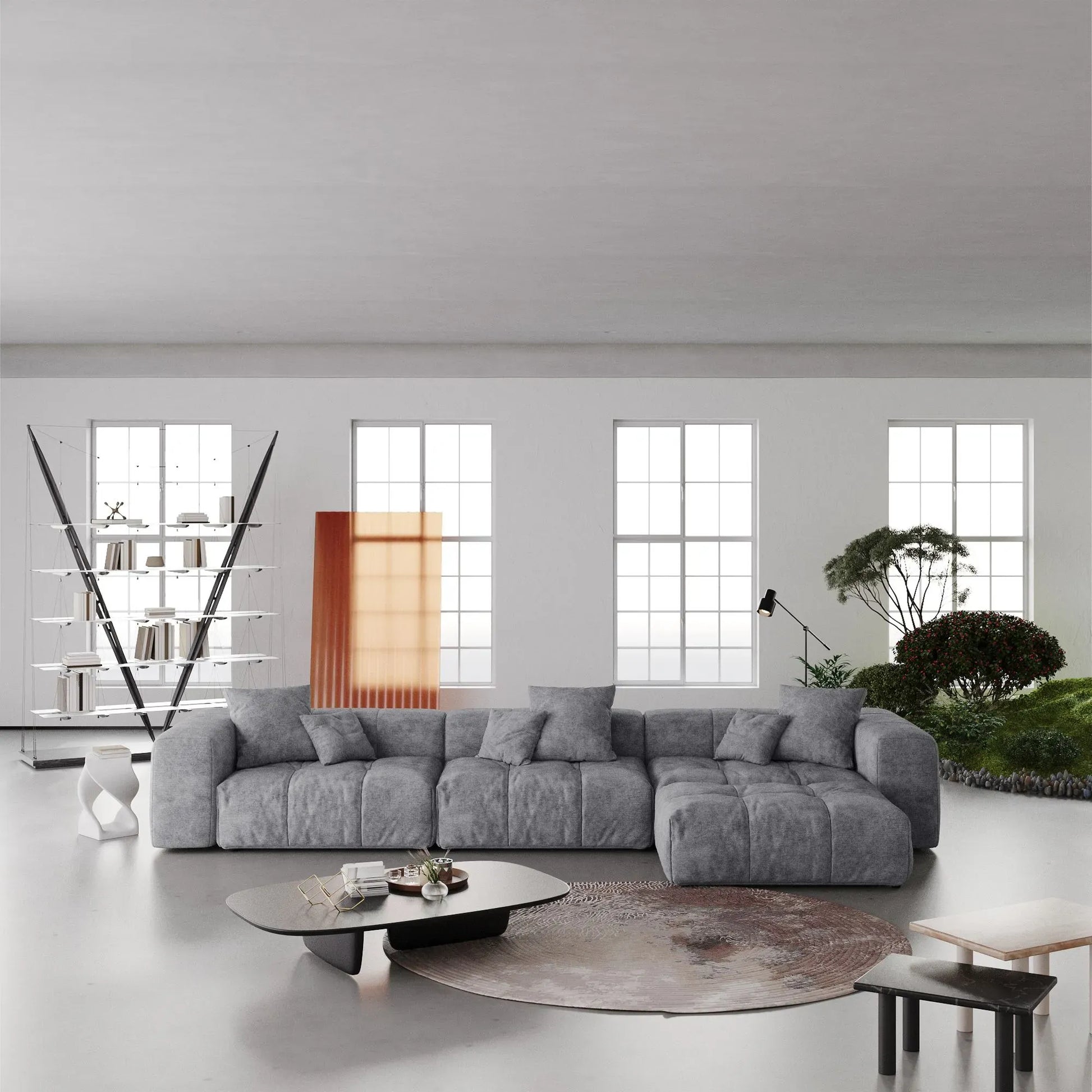 Modern living room with a large gray L-shaped sectional sofa, coffee table, and decorative elements.