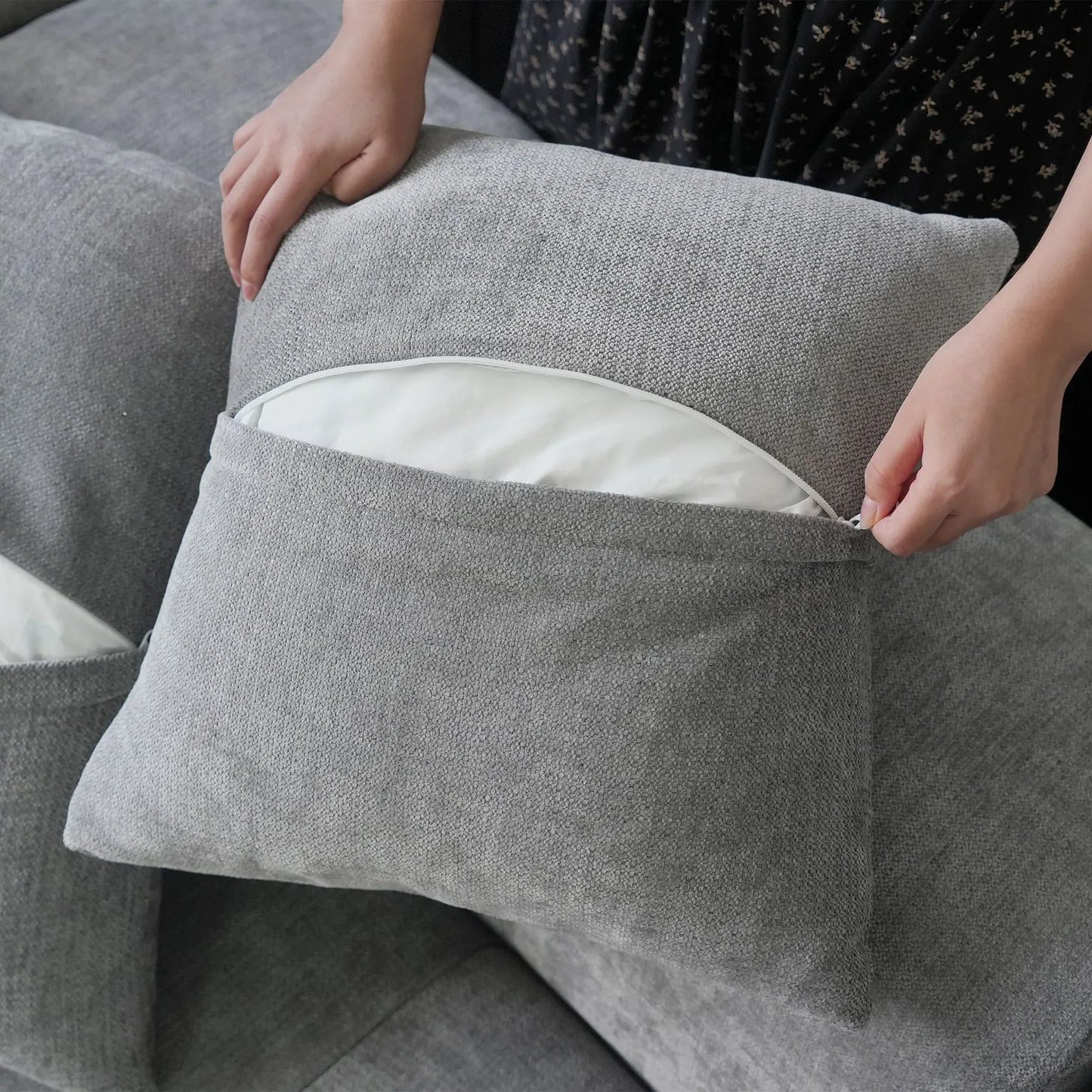 Close-up of an unzipped pillow case of a gray sofa