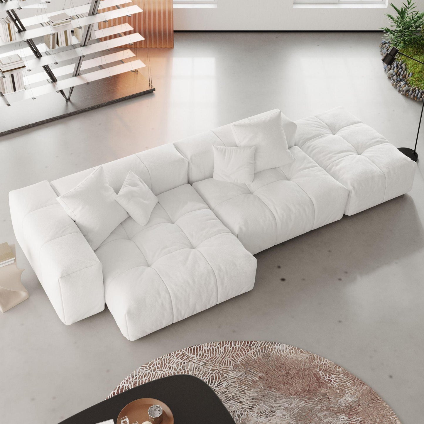 A modern, white 3-seat modular lounger sofa in white color with wide armrests and multiple accent pillows, arranged in a living room setting.