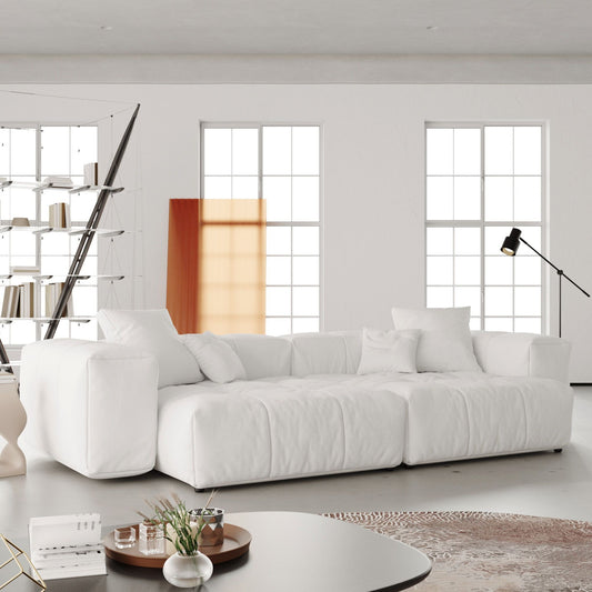 White loveseat sofa in a modern living room with large windows