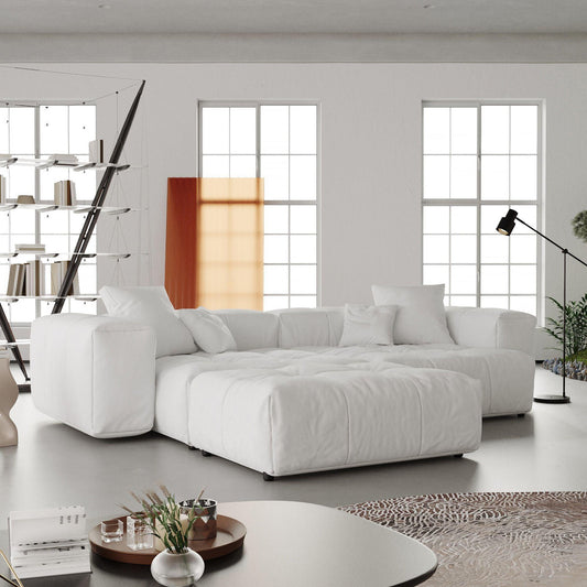 A modern linen modular loveseat with ottoman in a bright room, featuring a white color scheme and minimalistic design.