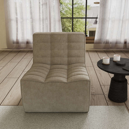 A khaki chenille accent chair with a minimalist design, positioned in a room with a window, curtains, and a small round side table.