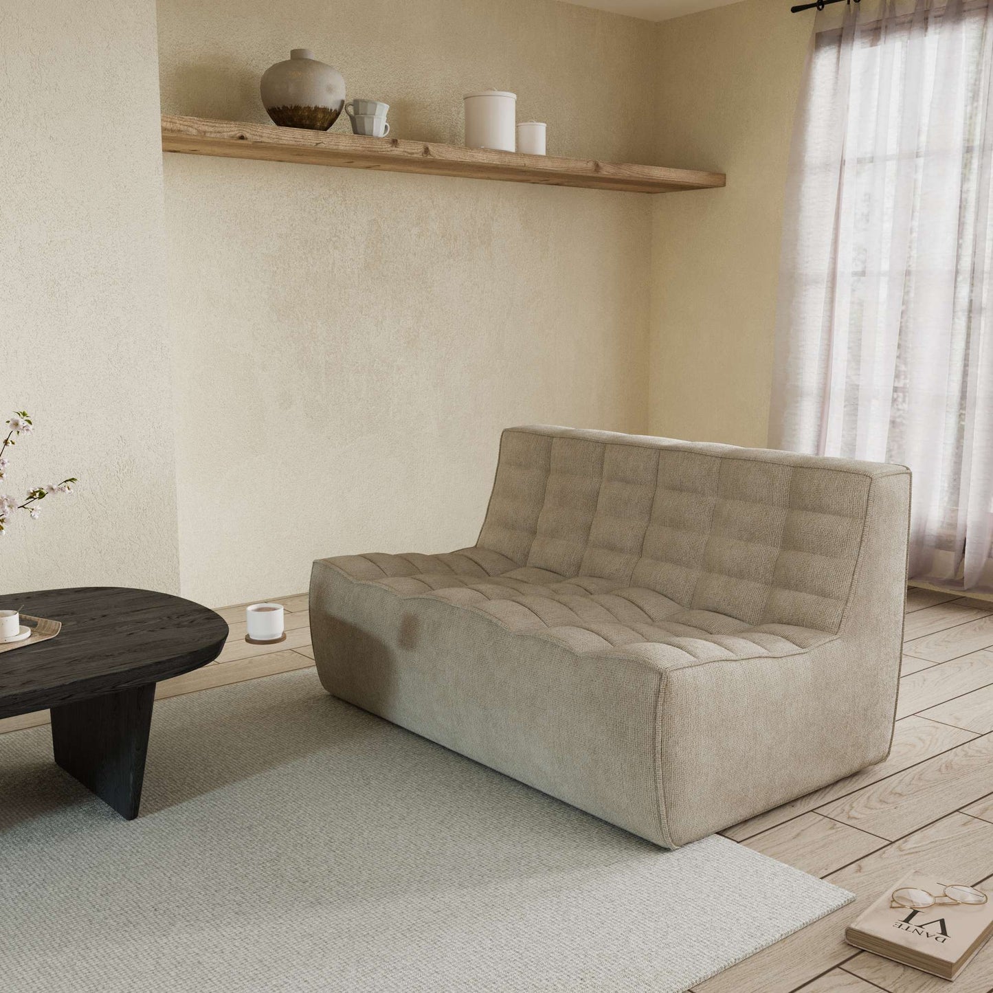 A khaki cotton-linen 2-seater ofa with an ergonomic caterpillar design, placed in a room with a window, curtains, a small round table, and a book on the floor.