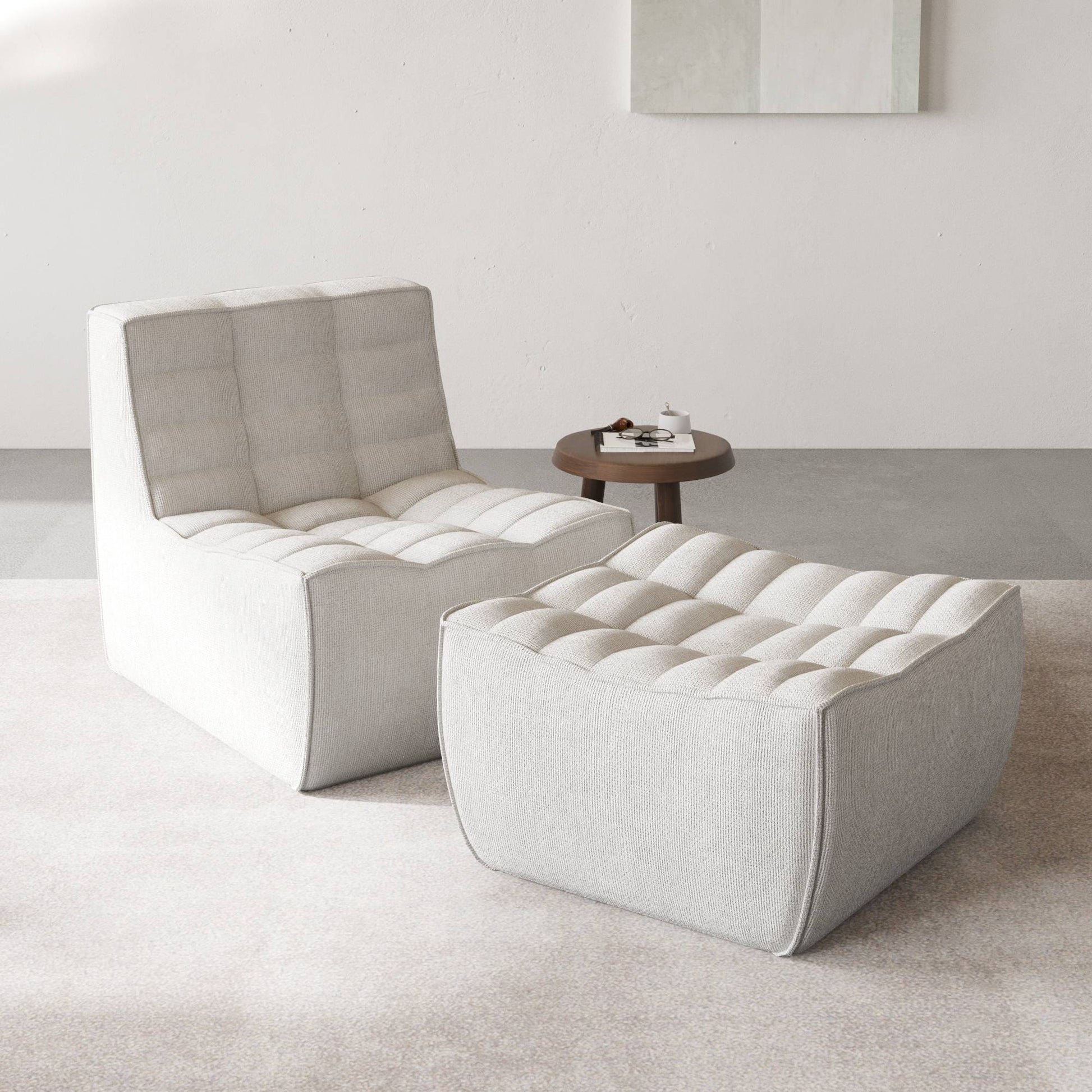 A light gray chenille accent chair and ottoman with a minimalist design in a day light