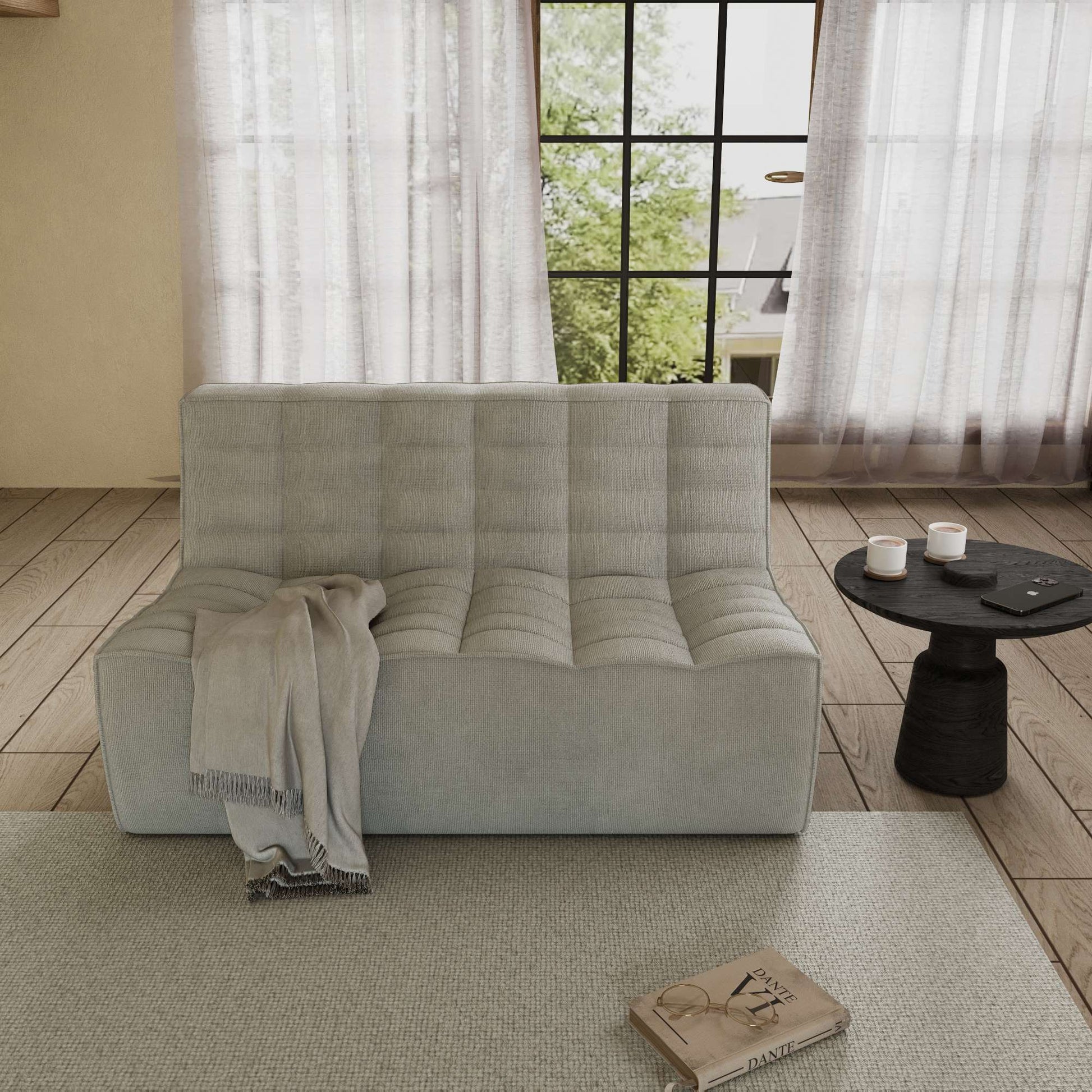 A light gray cotton-linen 2-seater sofa with an ergonomic caterpillar design, placed in a room with a window, curtains, a small round table, and a book on the floor.