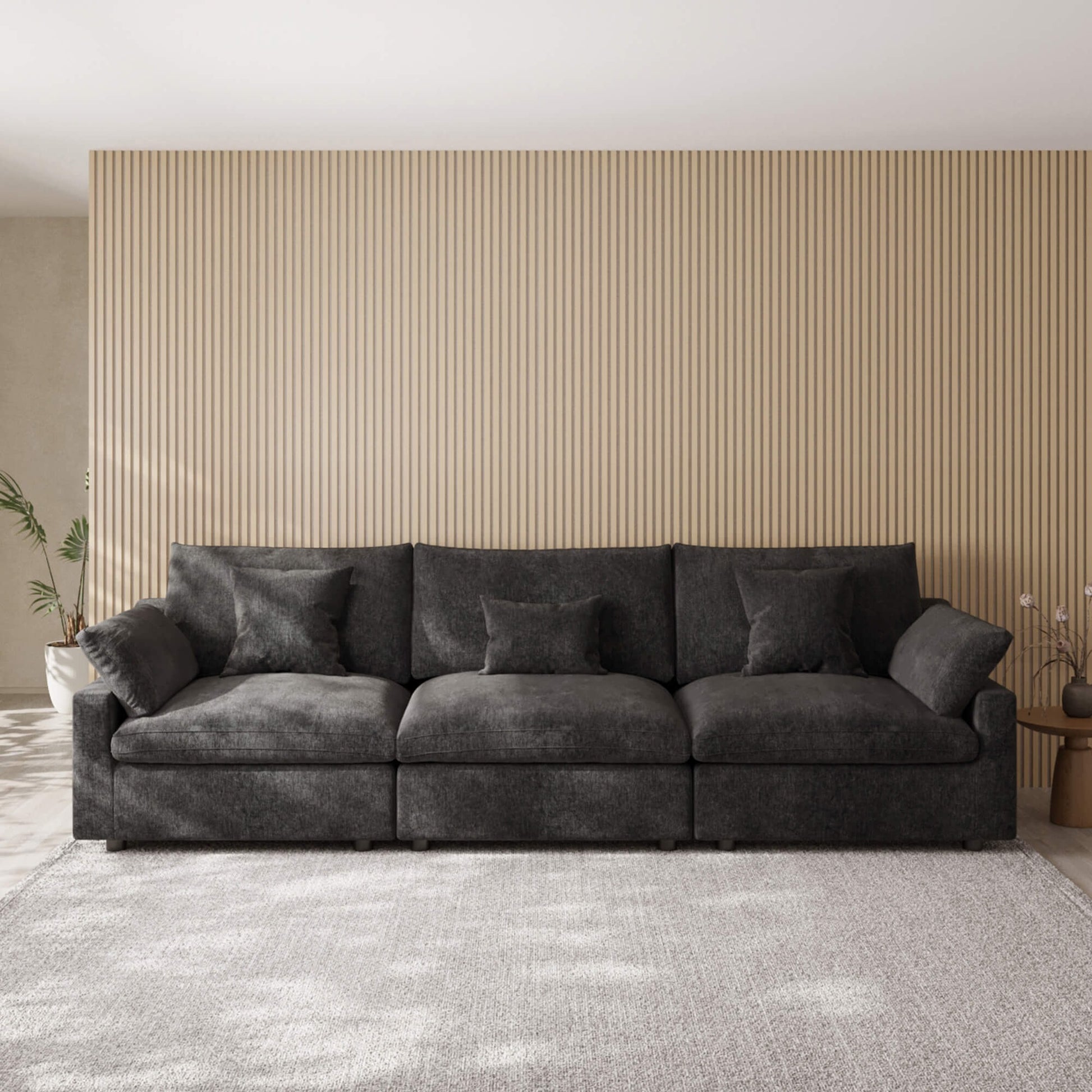 Black 3-seater sofa in a living room with striped wallpaper