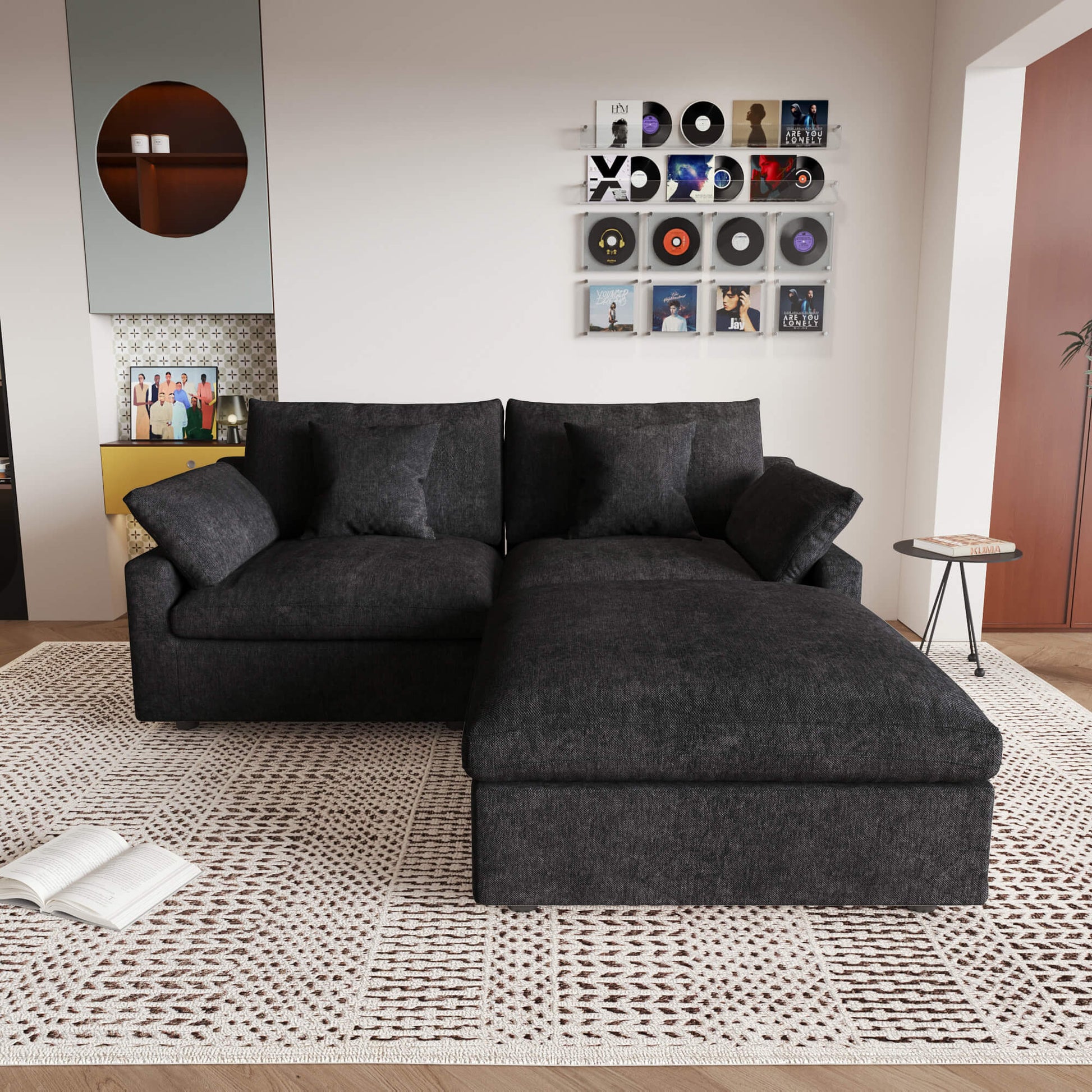 A black linen loveseat with ottoman, featuring a washable cloud design, placed on a patterned rug in a room with a record collection on the wall.