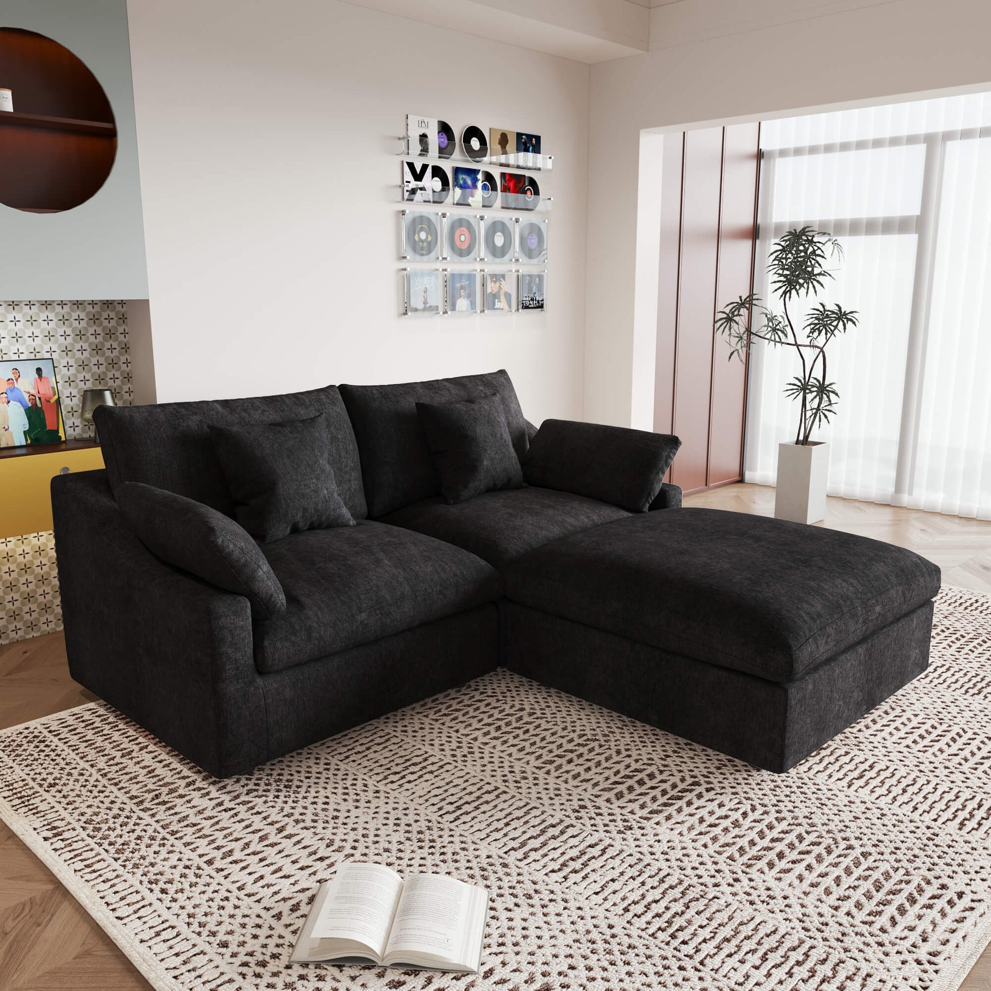A black linen loveseat with ottoman, featuring a washable cloud design, placed on a patterned rug in a room with a record collection on the wall.