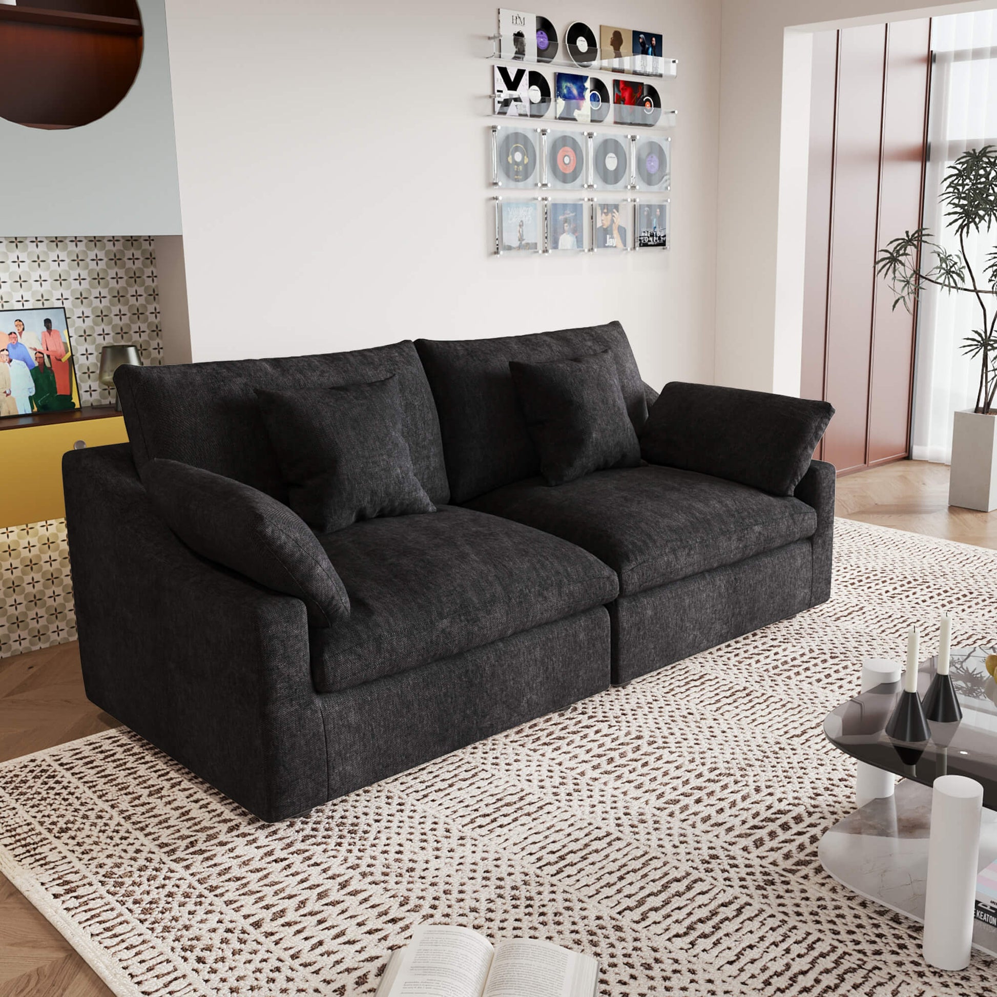 A black loveseat couch, featuring a minimalist design with removable cushions, placed in a room with modern decor.