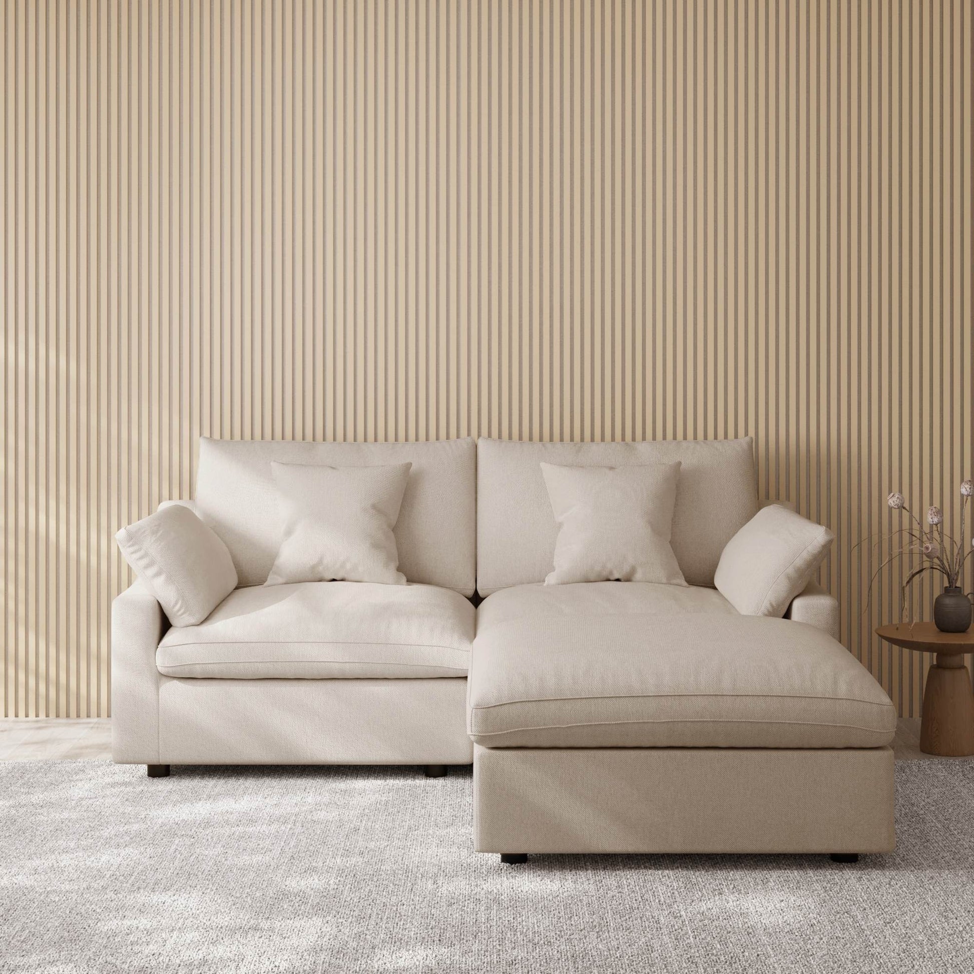 Khaki sectional chaise lounge sofa in a room with striped wallpaper