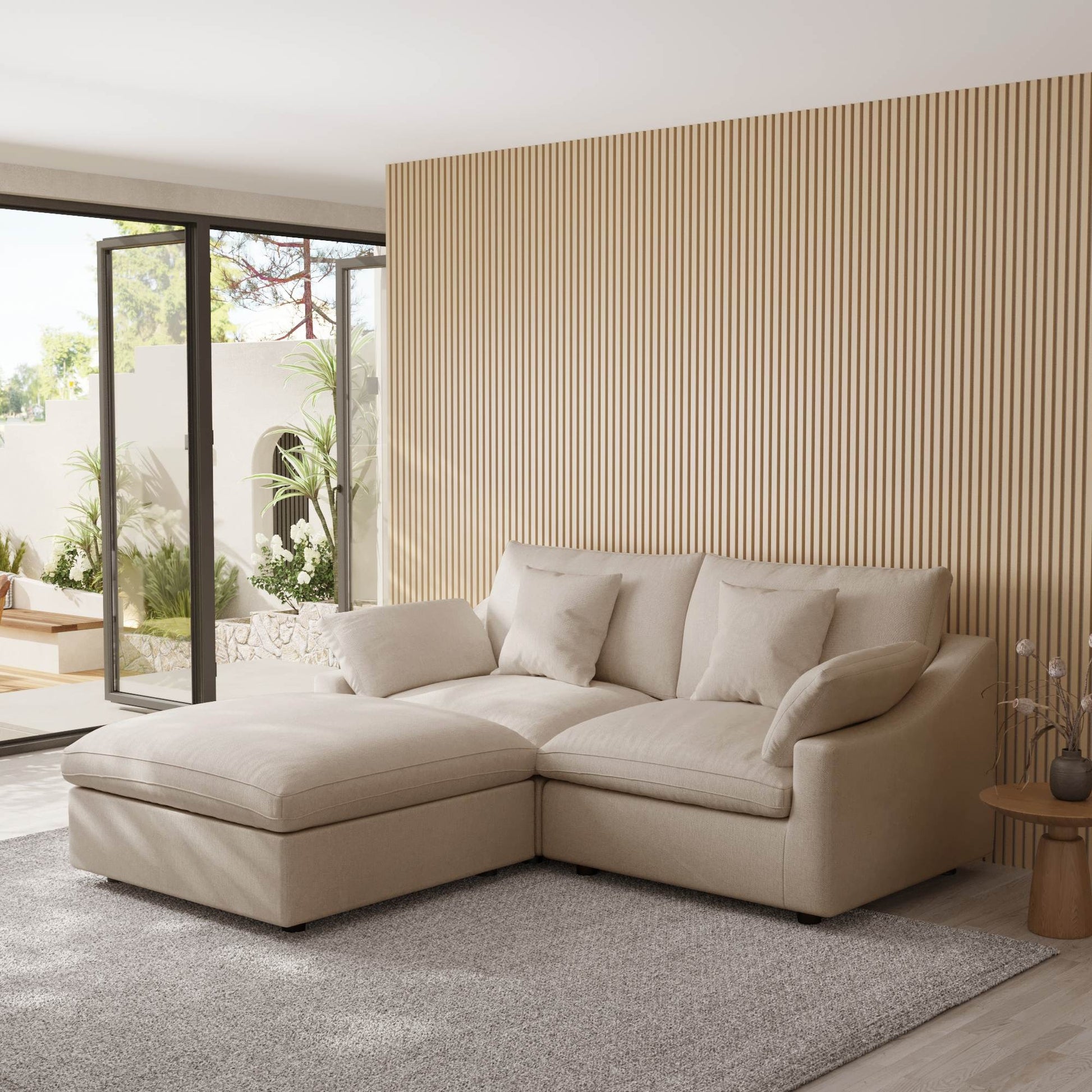 Khaki sectional chaise lounge sofa in a modern living room with striped wall and glass door.