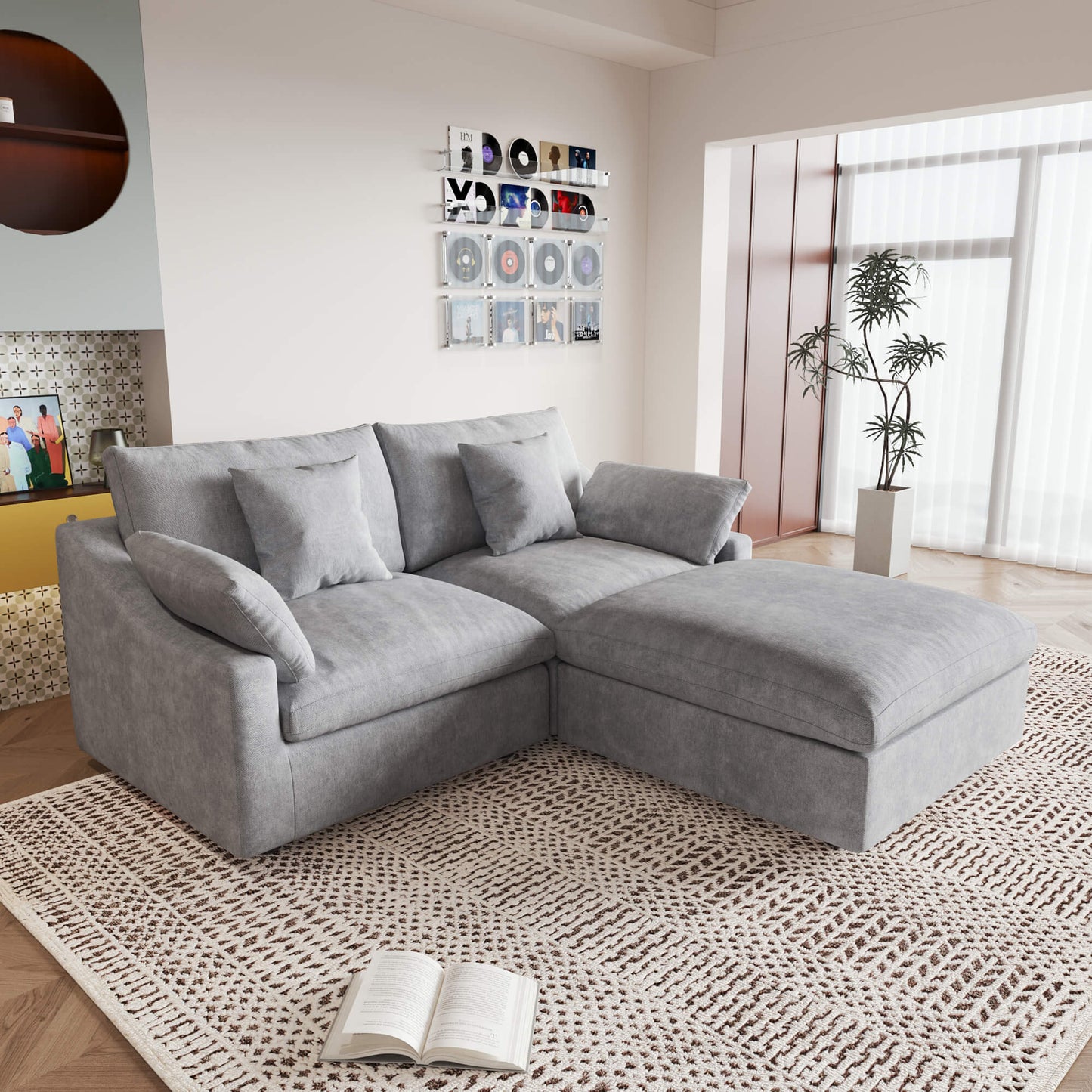 A light gray linen loveseat with ottoman, featuring a washable cloud design, placed on a patterned rug in a room with a record collection on the wall.