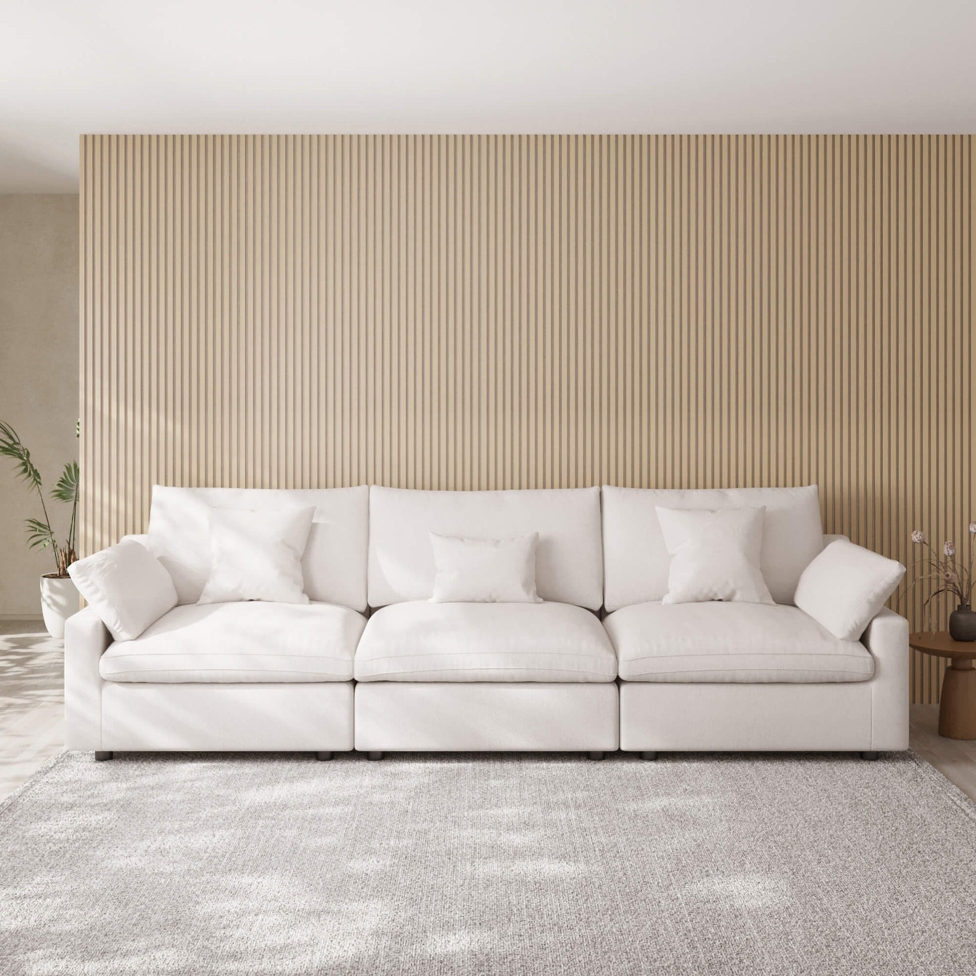 White 3-seater sofa in a living room with a striped wall and rug.
