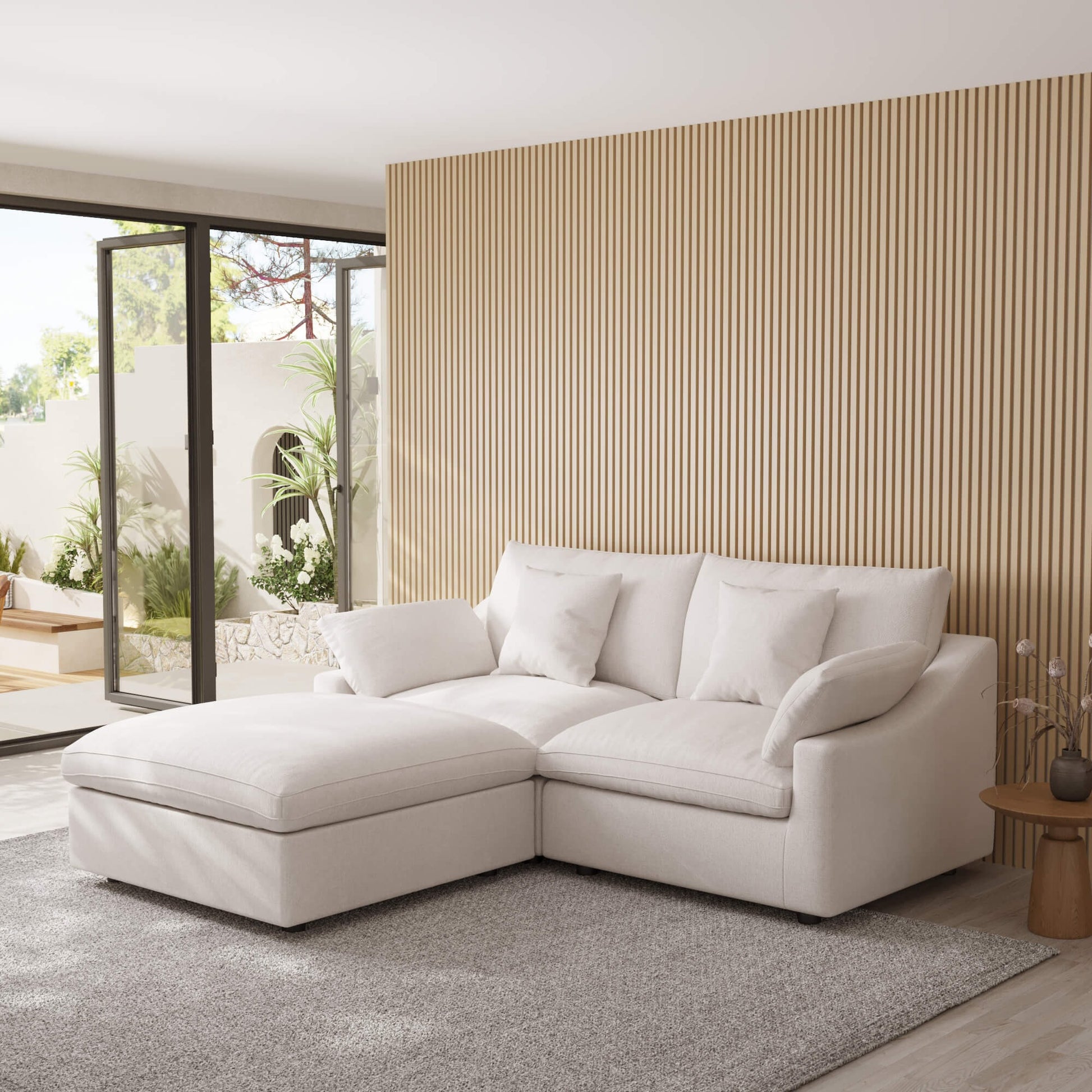 White sectional chaise lounge sofa in a modern living room with a striped wall and patio door.
