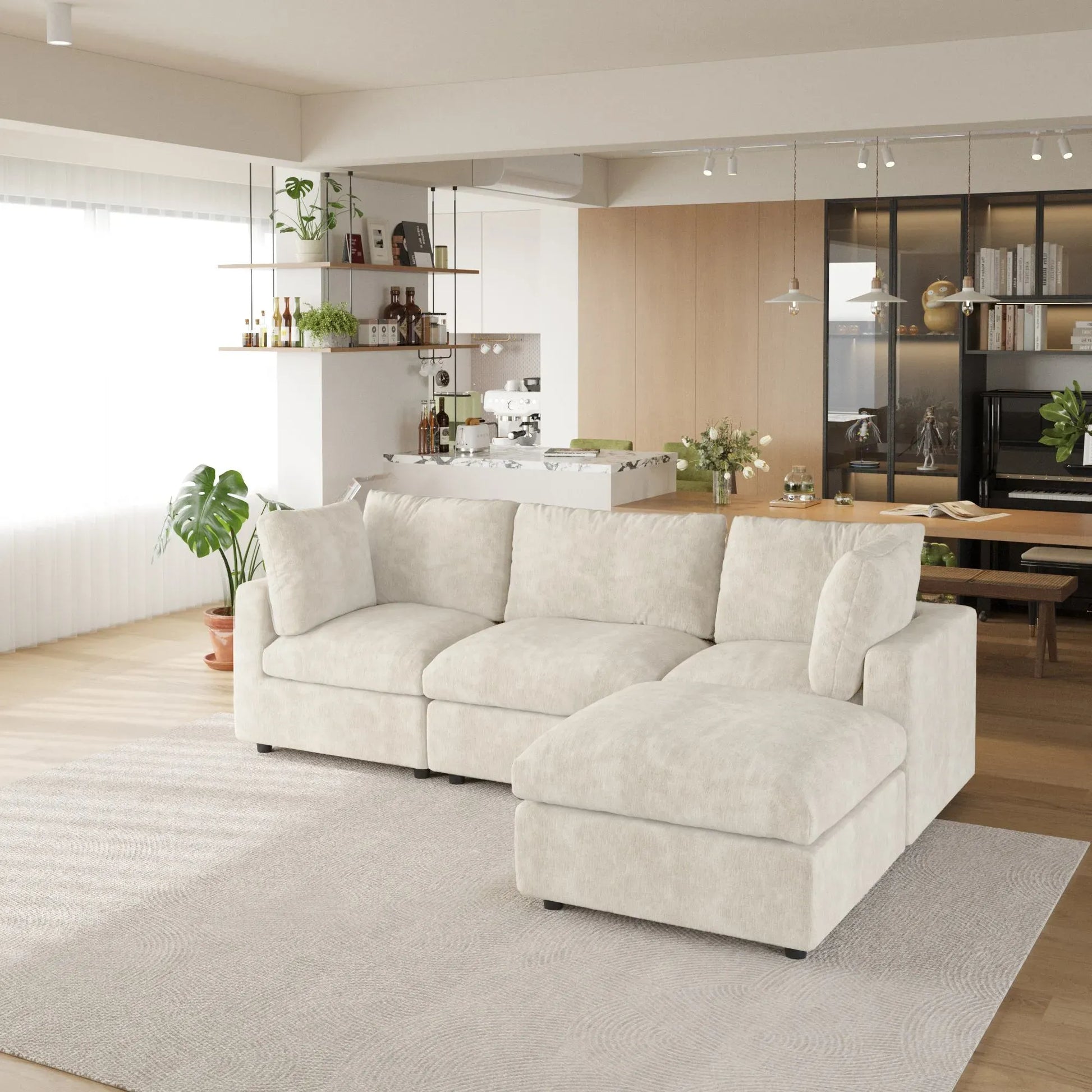 Beige L-shaped 4-seater sectional sofa in a modern living room with a kitchen in the background.