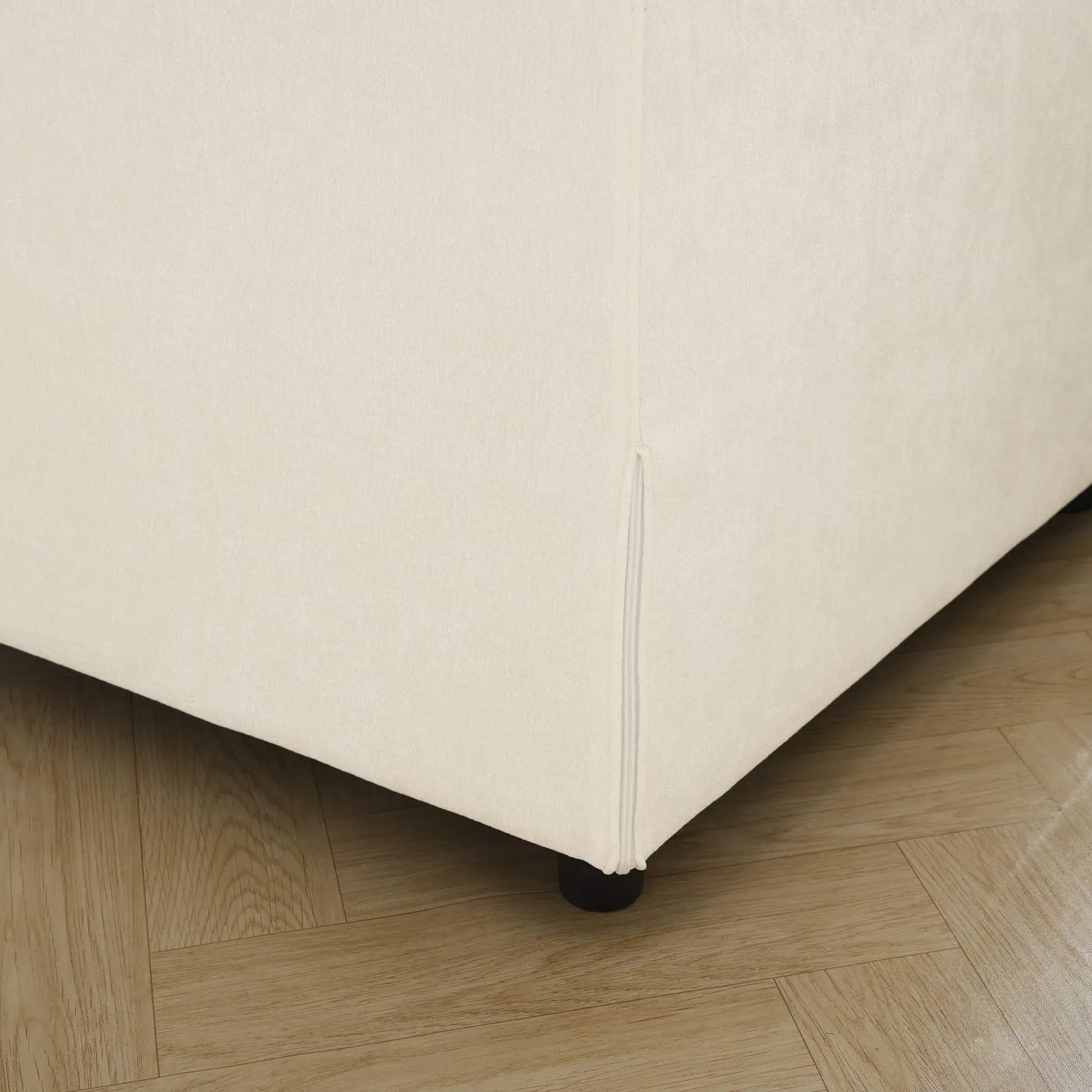 Beige upholstered sofa frame corner on a wooden floor