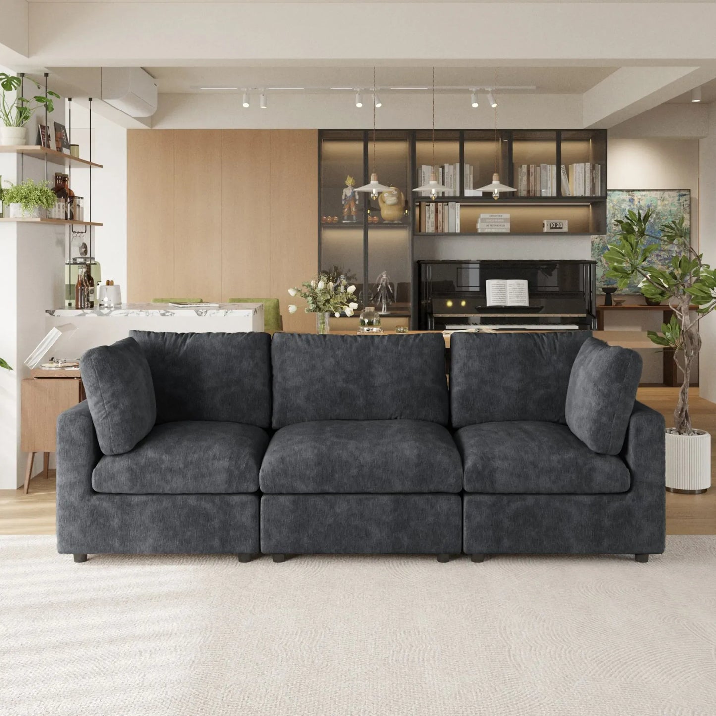 Black 3-seater sofa in a modern living room with a kitchen in the background