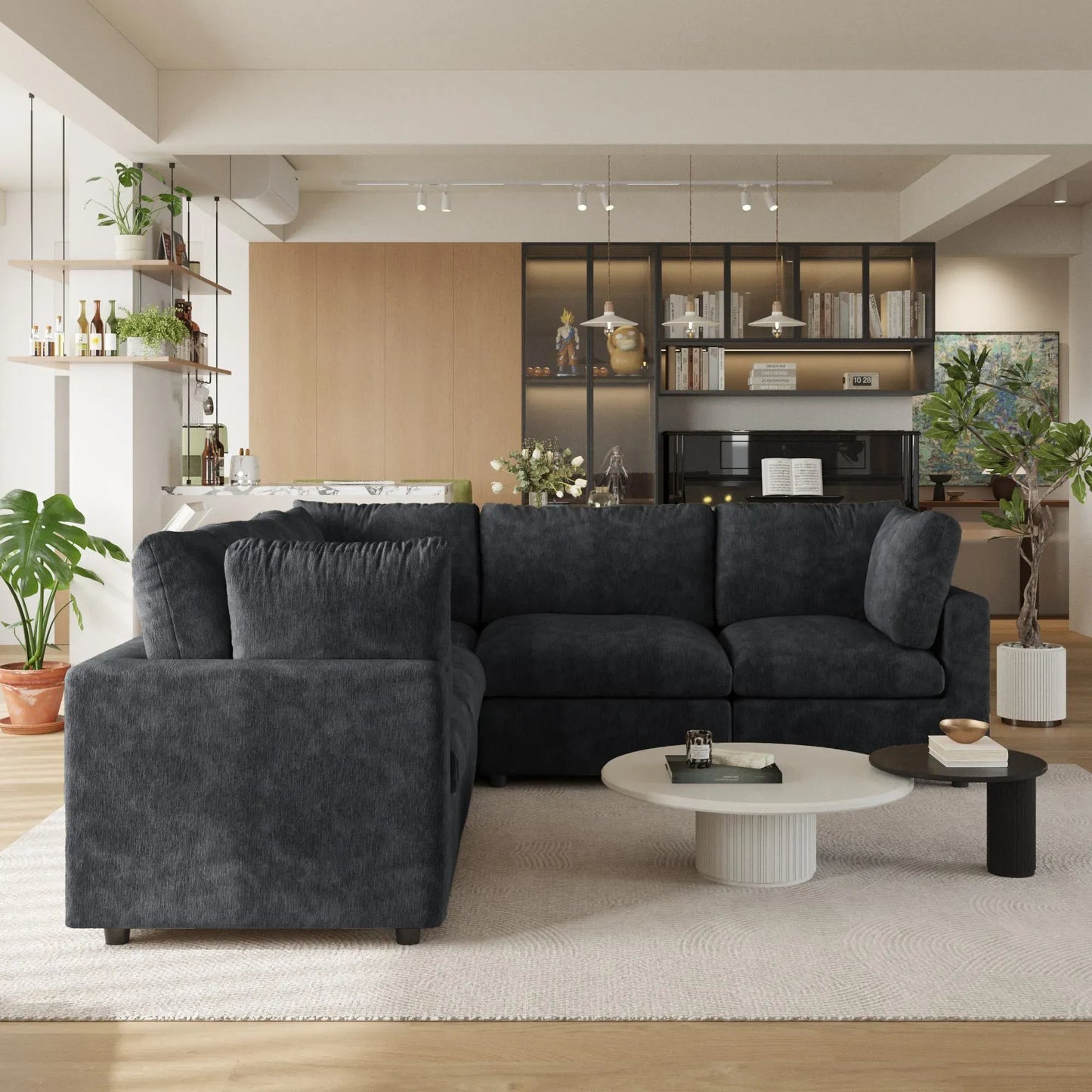 Modern living room with a black 5-seater corner sectional sofa, coffee table, and decorative items.