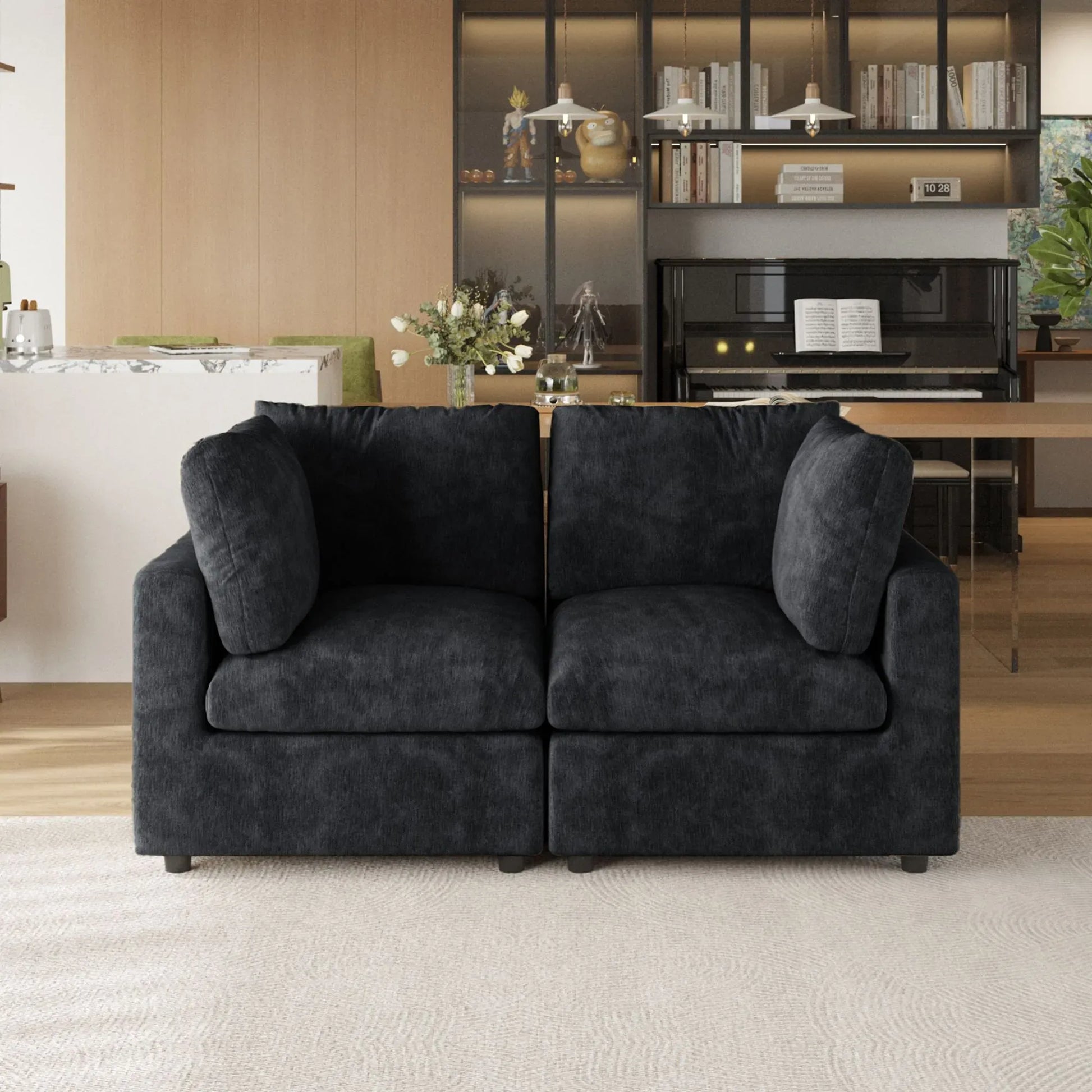 Black sofa in a living room with a bookshelf and piano in the background