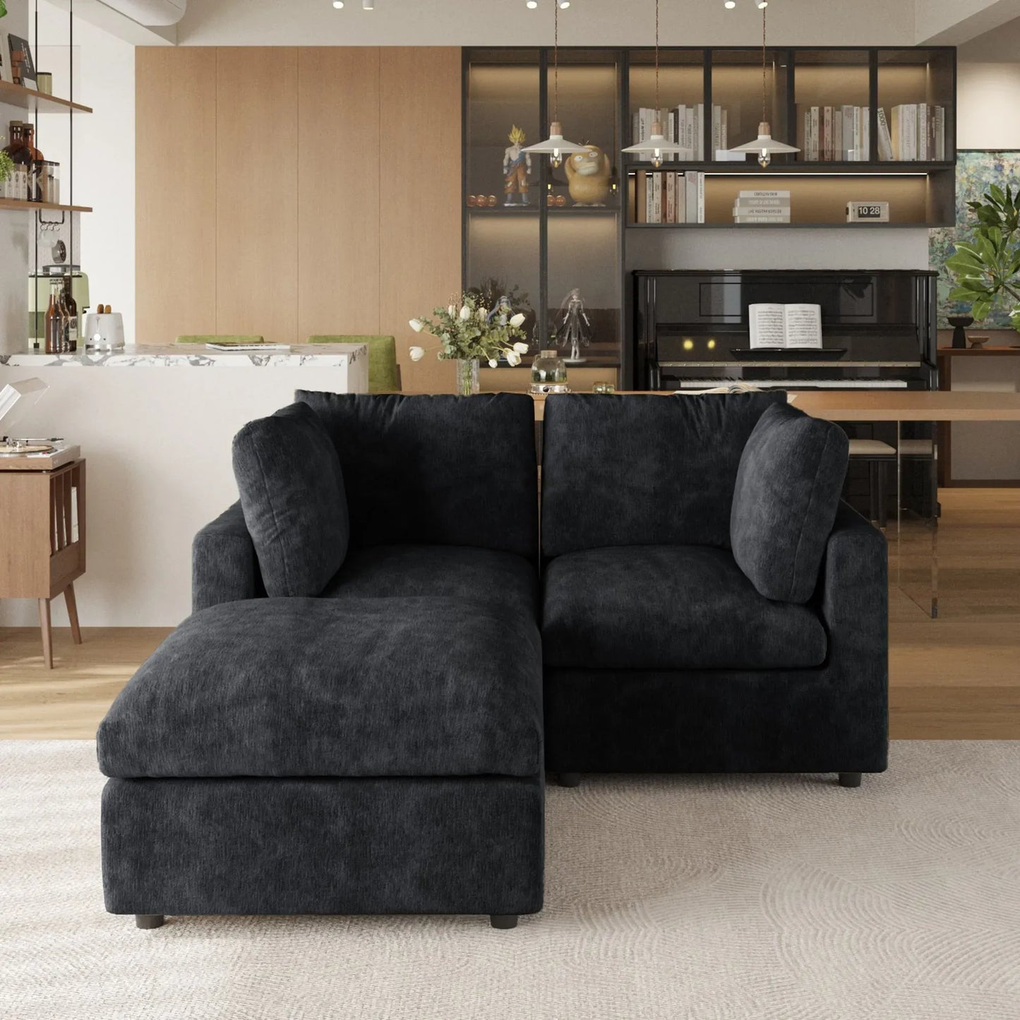 Black sectional sofa in a modern living room with a kitchen in the background.