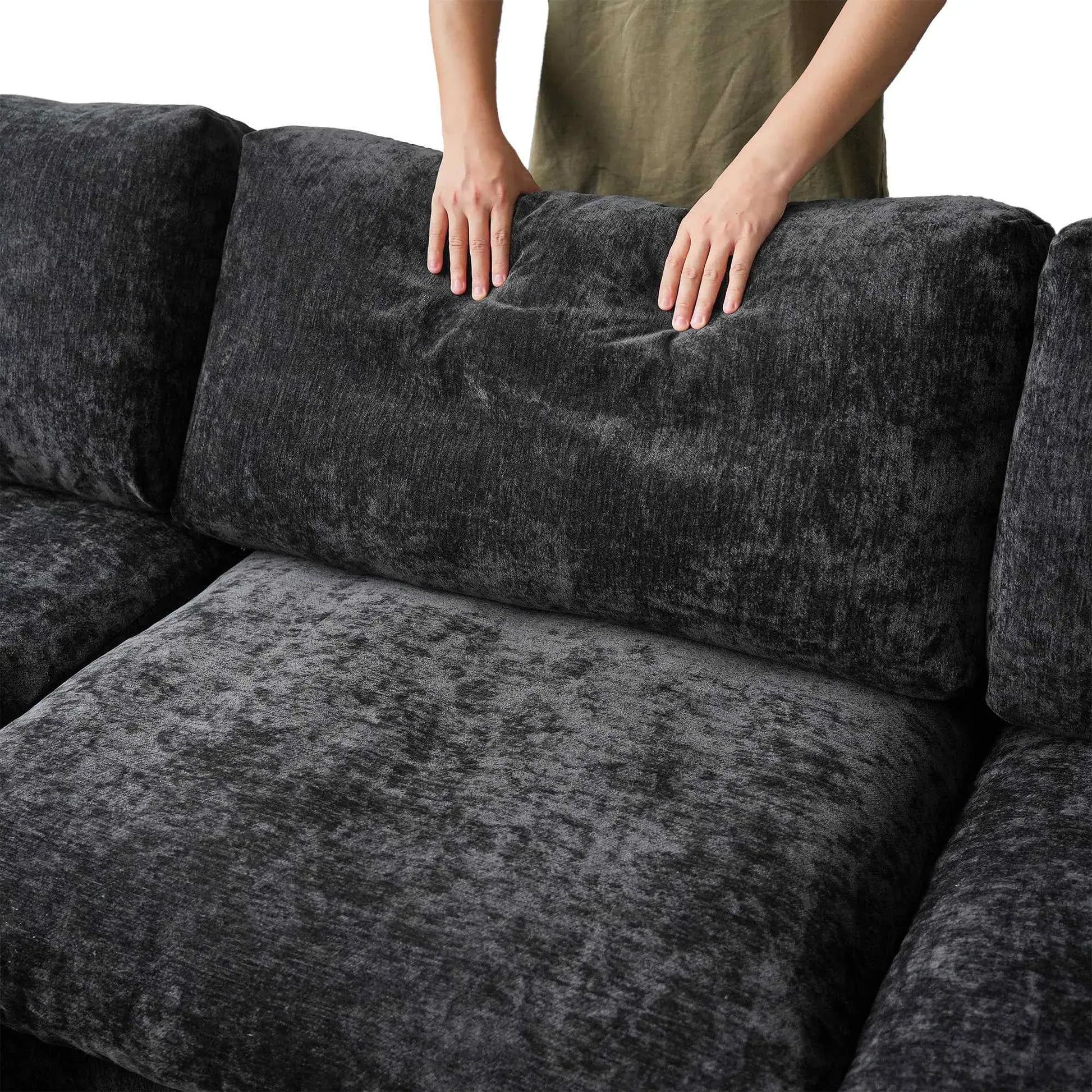 Black textured sofa with a person's hands on the backrest