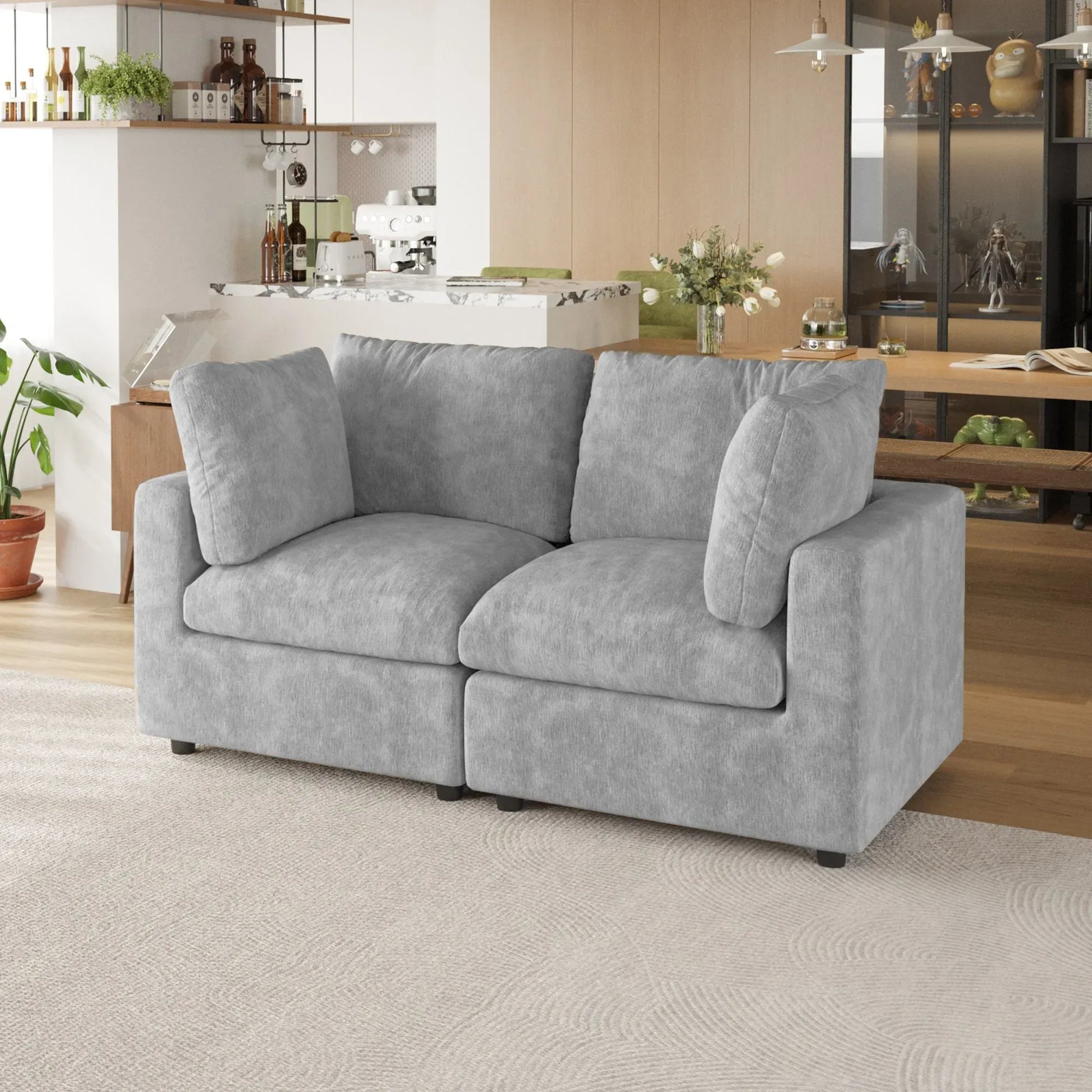 Gray sofa in a living room with a kitchen in the background