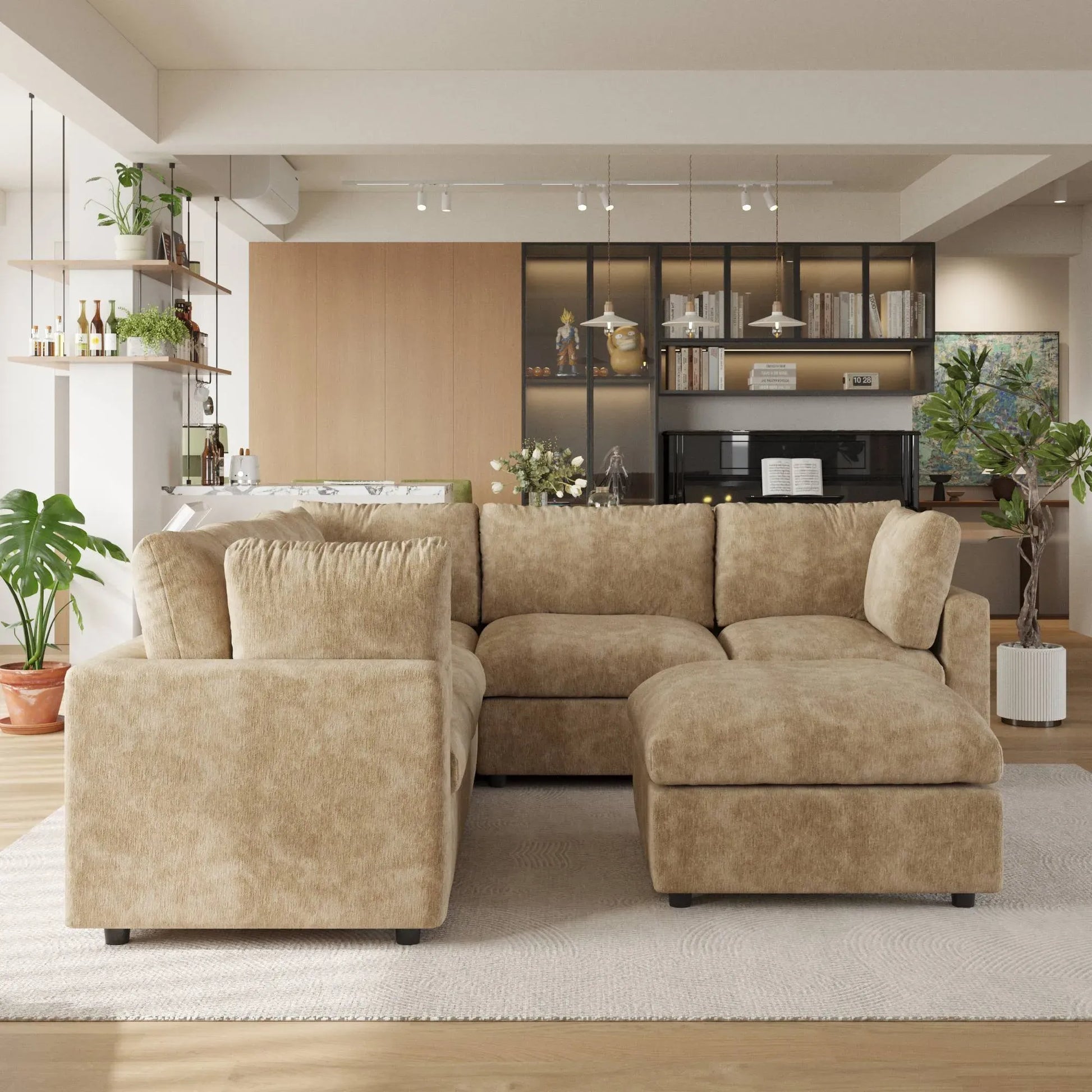 Khaki V-shaped corner sectional sofa with ottoman in a modern living room with decor elements.