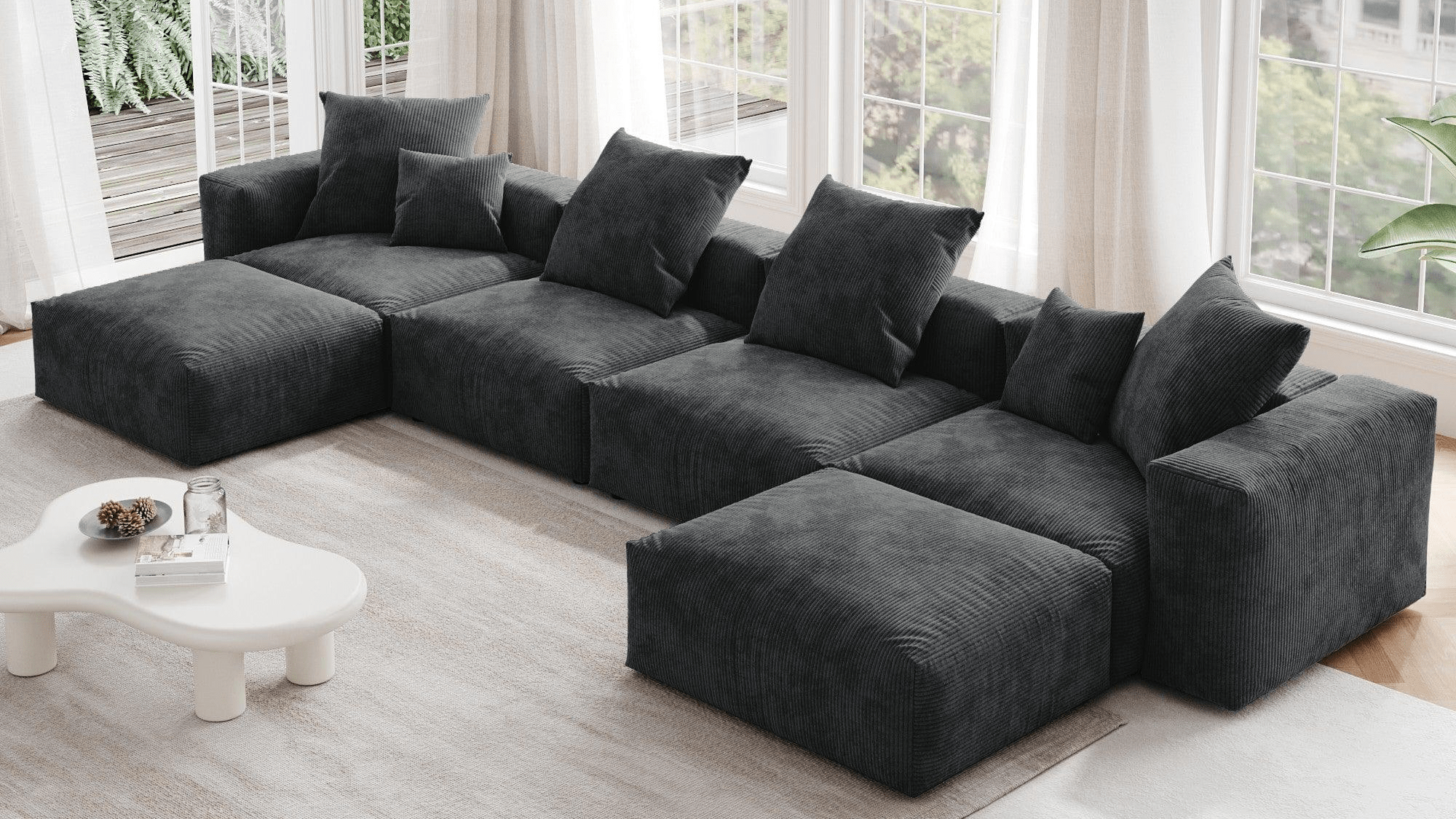 Black corduroy U-shaped sectional with replaceable washable covers in a room with floor windows.