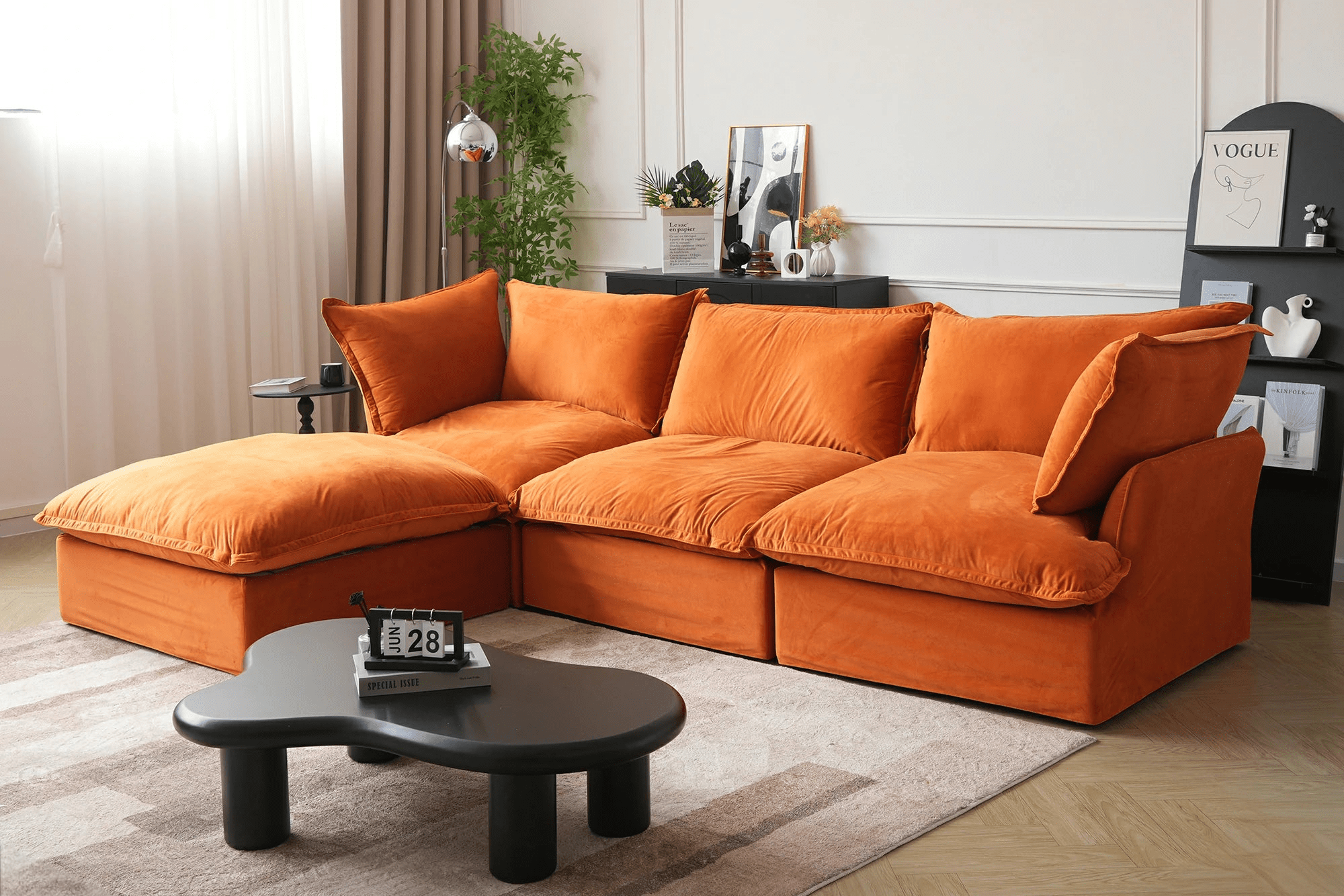 Orange velvet 3-seater with ottoman with washable covers next to black coffee table