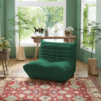 A green, caterpillar-shaped pet-friendly armchair placed on a patterned rug, featuring a modern ergonomic design.