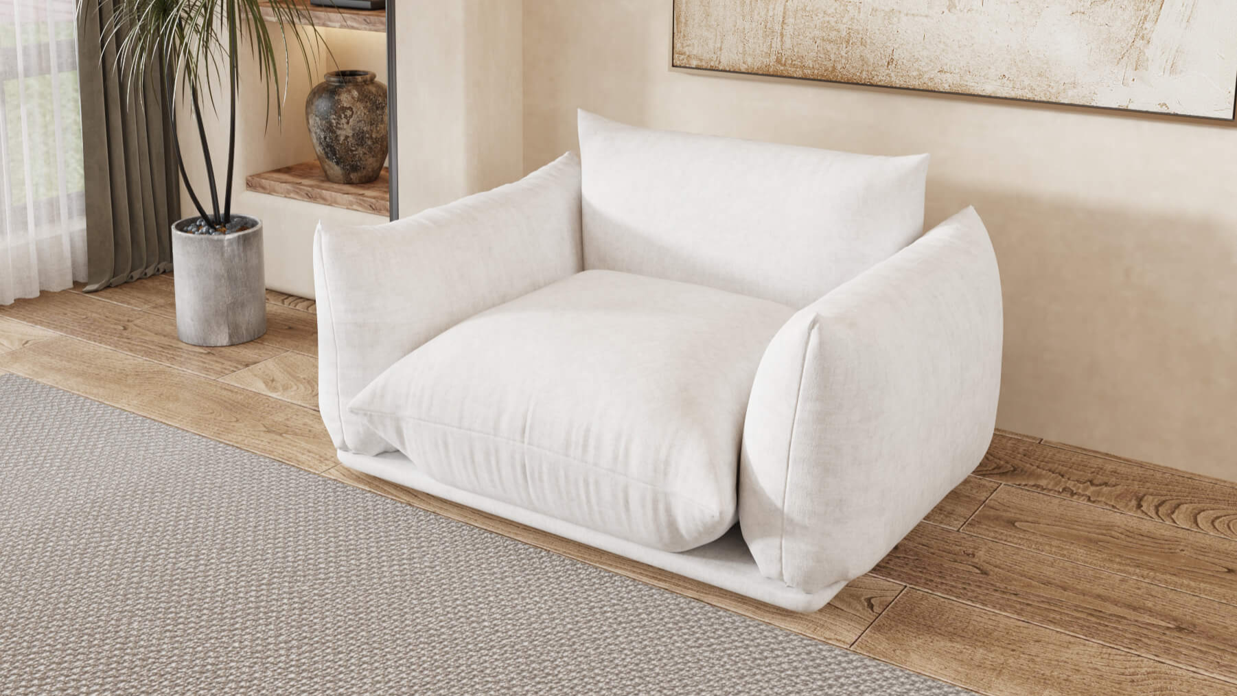 A white chenille armchair placed in a room with wooden flooring, under a painting on the wall, next to a potted plant.