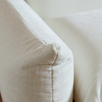 Beige overstuffed chenille armchair armrest detail