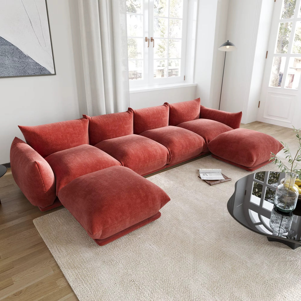 Red sectional sofa in a living room with a coffee table and decor items.