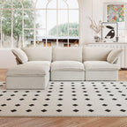 A beige L-shaped linen sectional sofa with a storage ottoman positioned in a bright room with large windows, alongside a patterned rug and in front of a wall with artwork.