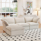 A beige L-shaped linen sectional sofa with a storage ottoman positioned in a bright room with large windows, alongside a patterned rug and in front of a wall with artwork.