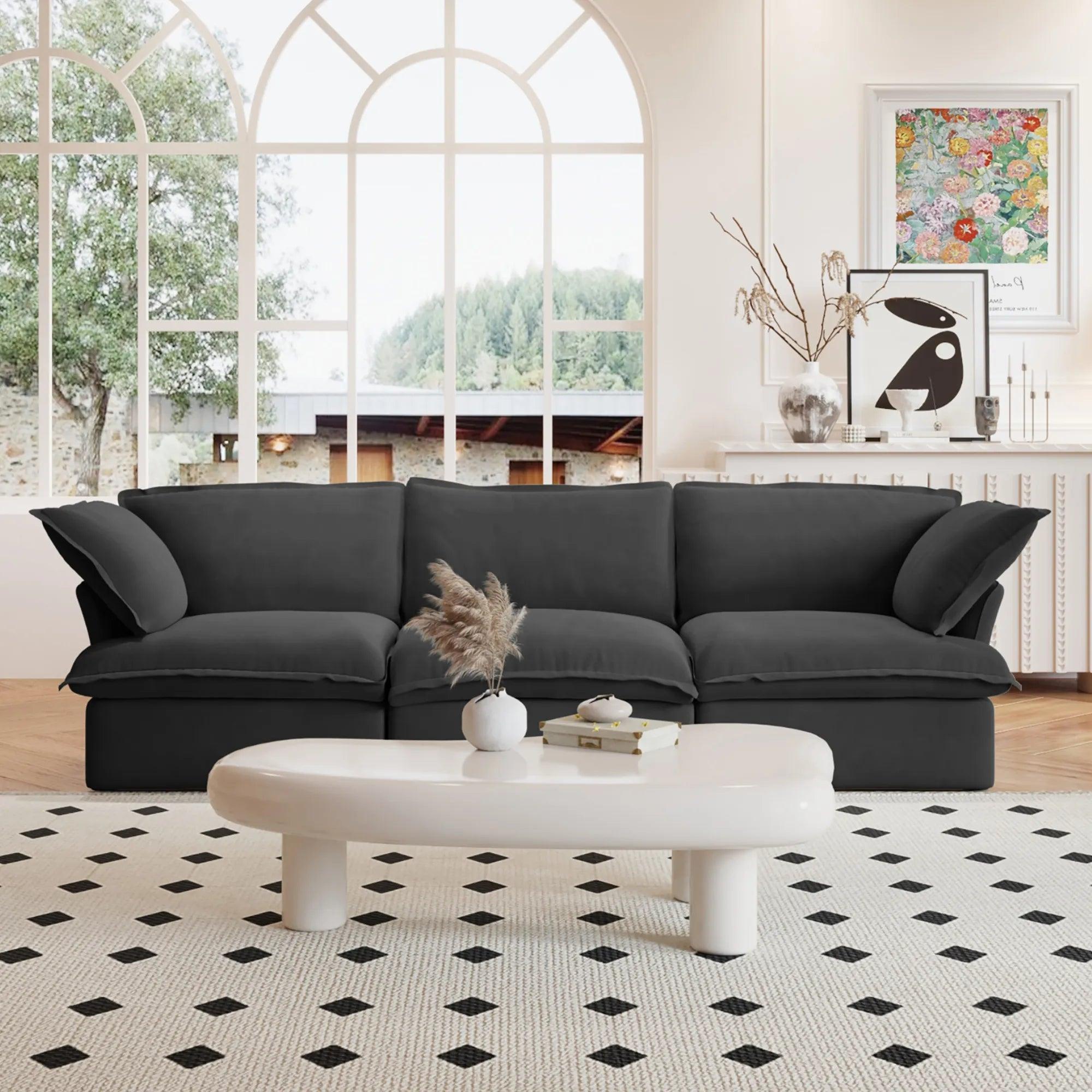 A black 3-seater linen sectional sofa in a modern living room setting with deep seating.