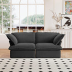 A black loveseat linen sectional sofa with modular design placed on a patterned rug in a bright living room setting.